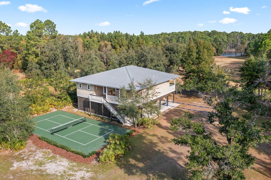 Built high and dry, this beautifully updated residence offers 3 bedrooms and 2 baths on the main level, including a dedicated bunk space perfect for kids or guests.  This home also offers additional sq footage as a private ground-level guest suite with a 4th bedroom ideal for extended family or visitors.

Designed for relaxed coastal living, the home features expansive covered outdoor space beneath the main level--perfect for entertaining, parking, or storing all your recreational toys. Enjoy quiet mornings on the front porch or unwind on the covered back deck that spans the entire width of the home, with direct access from the primary suite, guest room, living area, and kitchen. Set on over an acre of lushly landscaped grounds, there's ample room to roam, add a pool, garden, or simply enjoy complete privacy. For active lifestyles, the property also boasts its own pickleball court and volleyball court--bringing resort-style amenities right to your backyard.