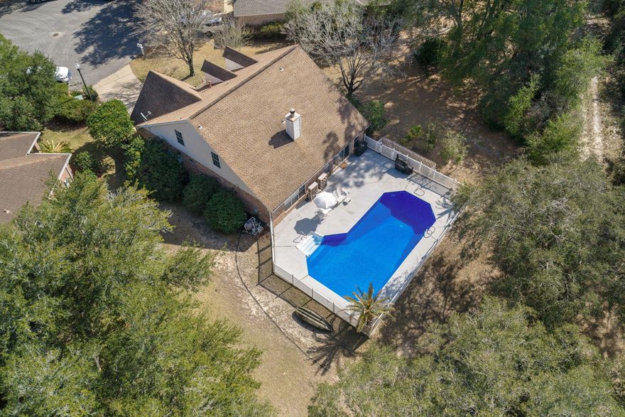 Pool Home in the Highly Desirable Gated Parkwood Estates in Niceville! Tucked away at the end of a quiet cul-de-sac and backing to a protected natural preserve, this 4-bedroom, 2.5-bath home offers privacy, vaulted ceilings, and a stunning 30,000-gallon pool designed for entertaining.
Located in one of Niceville's most desirable gated communities, this beautifully maintained home features abundant natural light, soaring ceilings, and a loft overlooking the main living area. Expansive windows frame the backyard oasis, allowing sunlight to reflect off the pool and fill the home with warmth.

The primary suite is conveniently located on the main level in a split floor plan design and overlooks the pool with serene preserve views. It has a large walk-in closet.  The en suite bath offers a soaking tub, separate walk-in shower, and an oversized double vanity that wraps the corner layout for maximum space and functionality.  Upstairs, all guest bedrooms are thoughtfully positioned for privacy, making this layout ideal. 
Step outside to your private retreat featuring a 30,000-gallon pool ranging from 4 to 10 feet deep, perfect for swimming, entertaining, and relaxing. The surrounding deck provides ample space for outdoor seating and gatherings. With no rear neighbors and mature trees throughout the lot, the setting is peaceful and private.

Additional highlights include a brand new hot water heater and a 2019 HVAC system. This is a rare opportunity to own a private pool home in Parkwood Estates, one of Niceville's most sought-after neighborhoods.