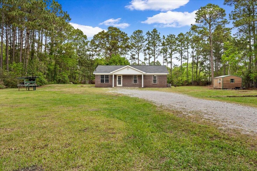 Escape to your private country acre--just minutes from the beach with no HOA. This impeccably maintained Milton residence offers a rare blend of seclusion and convenience, set on a cleared 1-acre homesite just 10 miles from Gulf Breeze Parkway and south of I-10. A gated drive framed by mature longleaf pines creates a serene, estate-like approach. The 3BR/2BA ranch features a timeless brick-and-vinyl exterior, inviting front porch, and an open, thoughtfully enhanced interior with luxury vinyl flooring. The updated kitchen showcases butcher block counters, white shaker cabinetry, and upgraded appliances. Enjoy a screened rear porch, detached storage/workshop, and expansive outdoor potential--just 25 minutes to the Gulf.