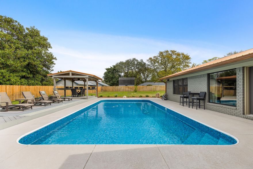 Amazing 5-bedroom brick home on a rare 0.70-acre lot in the heart of Destin with no HOA, offering space, privacy, and modern updates. This thoughtfully updated residence boasts a remodeled open kitchen with granite countertops & stainless steel appliances. No carpet throughout, just durable tile & luxury vinyl plank flooring, paired with fresh interior paint, creates a move-in-ready, clean aesthetic. This 3,508 sq ft home is designed for comfort, security, and peace of mind, with a new metal roof (2022), impact windows, and a Generac 24 kW whole-house generator. Additionally, the home is in Flood Zone X, meaning flood insurance is not required. The backyard retreat is designed for entertaining, complete with a heated pool, hot tub, grilling station, gazebo for outdoor dining, and an expansive pool deck surrounded by a large fenced yard for ultimate privacy. 

Inside, enjoy three cozy fireplaces, in the living room, den, and primary suite, along with updated bathrooms with new vanities and showers. A large front porch welcomes guests, and the 2-car garage with additional driveway parking for 4 vehicles ensures ample space for family and visitors.

Lifestyle and location are unbeatable! From this home, Joe's Bayou is less then 2 miles away, where you can launch your boat and be at Crab Island in just minutes, making spontaneous water adventures quick and easy. Additional nearby Destin attractions include HarborWalk Village, Norriego Point, Captain Leonard Destin Park, and Mattie Kelly Recreation Area and Pier. Daily conveniences like Publix and dining favorites such as McGuire's Irish Pub, Boshamps, Harbor Docks, and Marina Café are all within 5 miles from the home. 

This home offers a rare combination of a large, private lot, modern updates, and unbeatable access to Destin's waterways and attractions, a true opportunity to enjoy the ultimate Destin lifestyle!