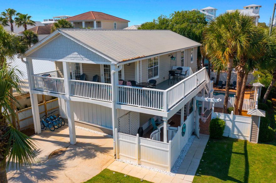 Elevated two-story income-generating property with two entirely independent, self-contained units, Private Pool & Expansive Wraparound Porches.The original upstairs built on stilts is a rare blend of history, craftsmanship, and coastal charm with wooden plank floors, a full-size dining area, updated kitchen with stainless-steel appliance, granite countertops, tumble-stone backsplash and a large pantry. The cozy vintage-style corner sofa was chosen for its' deep comfort and as a sandy-day hang-out spot with room for the whole family. Sleeping accommodation includes all NEW furnishings and bedding has a large Master bedroom, updated ensuite, twin-over-full bunk bedroom, updated full bath, washer and dryer.  Upstairs HVAC installed 05 28 2021 Water Heater 04 20 2010. The downstairs unit features a total, top-to-bottom remodel engineered and executed by licensed professionals, including a 18-inch elevation increase. Every component of this ground-floor space is completely brand new.  NEW Engineer designed Monolithic Concrete Slab, NEW High-end Poured terrazzo flooring, NEW cabinets, NEW appliances, NEW Impact rated door and repurposed windows, NEW bathrooms, NEW Electrical Panel and all new wiring, , NEW Water Heater 04 20 2025, HVAC 05 28 2022, NEW Furnishings, NEW! NEW! NEW!  This dual-occupancy layout offers distinct, self-contained units--complete with private entrances, kitchens, baths and washer/dryer. Sold Fully, NEWLY furnished, rental ready (accommodates 17 guest) NO HOA Enjoy your own private pool in a fenced-in oasis, complemented by beautifully appointed communal lounging areas, with backyard grill and picnic table. Steps to the beach via an exclusive private gate or relax at the expansive community pool. Local Winery, eateries and shopping all within walking distance. Large malls, theaters, entertainment and famous seafood restaurants within a two-to-five-mile driving distance.  All facts and measurements deemed to be accurate and should be verified to consumer satisfaction.