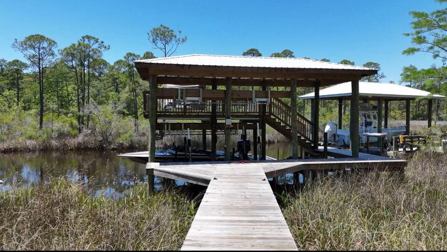 Bring your boat and live the waterfront lifestyle most buyers spend years trying to find -- this rare bayou-front property is one of only 7 homes in the neighborhood with direct deep-water access to the bay. Located just 5.5 miles from Seaside and the beaches of 30A, 233 Maddox Street offers the perfect blend of boating, privacy, and coastal living in a quiet non-rental community.

The centerpiece of the property is the newly constructed $180,000 custom double-stall boathouse featuring two lifts, covered slips, a spacious upper-level sundeck, and easy access out to the bay for fishing, cruising, waterfront dining, and sunset rides. Whether you're an avid boater or simply want to enjoy life on the water, this setup is exceptionally hard to find in this price range and location.

Inside, the home has undergone approximately $300,000 in upgrades and improvements, creating a move-in-ready coastal retreat designed for both everyday living and entertaining. The property offers the rare opportunity to enjoy a true waterfront lifestyle without the short-term rental traffic common in many nearby beach communities.

If you've been searching for a home that delivers boating convenience, privacy, and proximity to 30A, this is a unique opportunity to own one of the area's most distinctive waterfront properties.