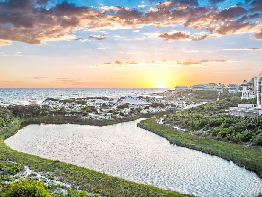Few addresses along Florida's Gulf Coast can claim what 40 Tortola Lane delivers: an elevated position on one of The Retreat's most prized lots, with an unobstructed panorama stretching across Draper Lake, the gulf's white-sand dunes, and the shimmering open water beyond. This stacked layering of coastal dune lake, sculpted dunes, and gulf horizon is a combination virtually impossible to find -- and it defines this property as something genuinely extraordinary. Priced to reflect exceptional value, this is a rare opportunity to own one of the most architecturally refined and scenically positioned homes on 30A at a compelling entry point. Designed by celebrated architect Tom Christ and constructed to fortified home standards with steel-reinforced concrete and a decorative concrete tile roof, the home is built for both beauty and longevity. Multi-level balconies extend the living experience outdoors, where the coastal views are nothing short of breathtaking. The second floor serves as the home's social hub with soaring ceilings, rich hardwood floors and a stone fireplace that sets the tone for a living space that is both welcoming and refined. The chef's kitchen is outfitted for serious entertaining, featuring dual islands, Thermador appliances and quartzite countertops. A guest suite, an office/bedroom room with ensuite bath, and a powder room round out this level. The entire third floor is dedicated to a primary suite with views of Draper Lake, the dunes, and the gulf, providing a backdrop that makes waking up here feel like an event. Custom his-and-hers closets with a built-in safe, a private den with fireplace and a secondary laundry add layers of comfort and practicality. On the first floor, three additional guest suites each feature en suite baths. A bright courtyard, mudroom, and connected outdoor shower make post-beach and post-lake transitions effortless. A cedar closet, a climate-controlled wine room, and a heated and cooled storage room - spacious enough to double as a private gym or wellness studio - round out the home's thoughtful amenities. The property sits within The Retreat, widely regarded as 30A's most private and meticulously maintained gated enclave. Residents enjoy over 3,000 feet of private gulf frontage, a world-class pool and beach club, and access to Draper Lake's boathouse for kayaking and paddleboarding. An expansive natural buffer surrounding the community ensures the kind of enduring privacy that is increasingly rare. At its new price, 40 Tortola Lane stands as one of the most compelling values on the entire Emerald Coast -- a legacy property offering unmatched views, superior construction, and the exclusivity of The Retreat, all at a price that rewards decisive buyers.