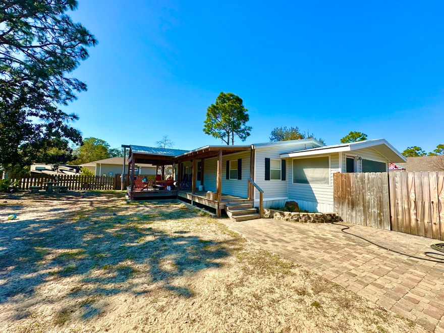 $5,000 to Buyer at closing! Set in a highly desirable, fast-growing neighborhood surrounded by attractive new construction, this property offers both comfort and long-term value in a well-connected area with convenient access to beaches, 30A, schools, shopping, dining, and everyday amenities. With 1,215 square feet of updated living space this 3 bedroom, 2 bath manufactured home sit on a spacious 0.27 acre lot with fenced front and back yards Built in 2002 with the addition of a sizable covered front porch creates a comfortable outdoor gathering space. The metal roof is approx. 10 years, and AC replaced about 6 years ago. Remodeled kitchen and baths elevate the space along with an 800 square foot detached garage/workshop with the additional storage space. Schedule a private showing today!