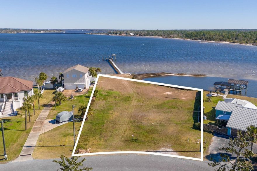 A rare stretch of North Bay shoreline sets the stage for something extraordinary. Spanning 1.2 acres with an impressive 222 feet of deepwater frontage, this offering presents a remarkable canvas for a custom waterfront estate defined by space, privacy and possibility. A solid seawall is already in place, along with a large private dock and boat slips, allowing you to step straight into the bayfront lifestyle from day one. Launch at sunrise, cruise at sunset or simply let the rhythm of the water shape your days. With deepwater access, boating enthusiasts will appreciate the freedom and flexibility this setting affords. What truly distinguishes this property is its own small island feature, creating a natural buffer and a protected cove feel just off your shoreline. The result is a uniquely  intimate waterfront experience, where calm waters and wide open bay views exist in perfect balance. It is a setting that feels both expansive and tucked away, offering room to design a legacy home with sweeping outdoor living spaces, a resort-style pool or lush coastal landscaping framed by panoramic water vistas. Located in College Point and near Isaac Bird Park, this homesite pairs serene bayfront living with convenient access to green space and recreation. Properties with this much frontage, acreage and character are increasingly scarce. Here, the foundation for your vision is already in place; all that remains is to bring it to life.