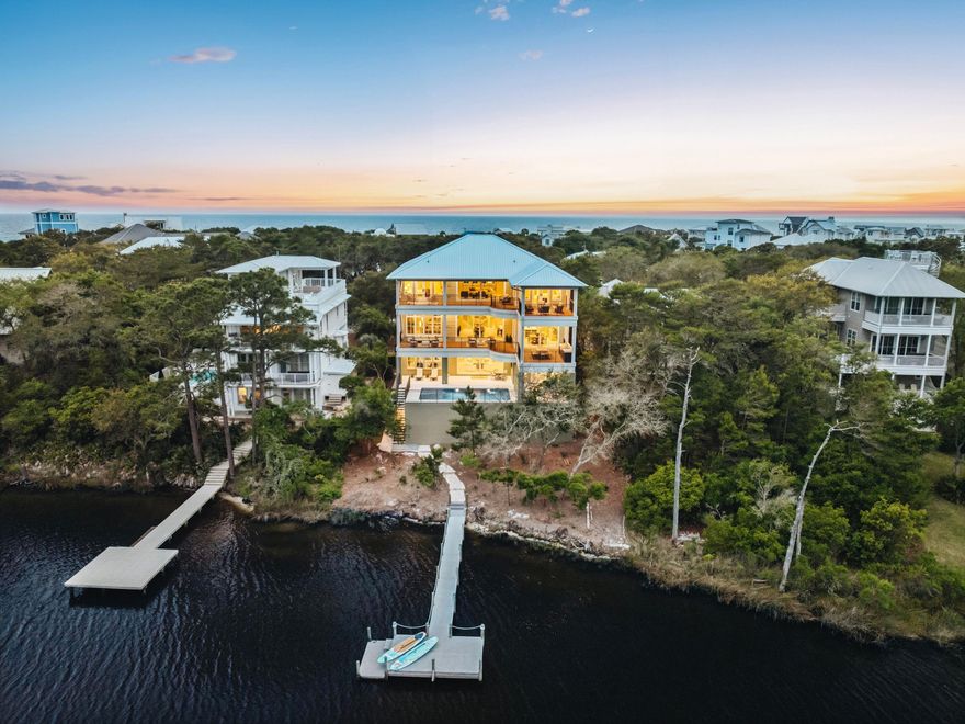 Positioned along the coveted west end of Scenic Highway 30A and just moments from the sugar-white sands of the Gulf, 157 Blue Lake Road offers a rare blend of beachside convenience, lakefront serenity, and coastal sophistication. Nestled within an intimate waterfront enclave along the shores of Big Redfish Lake, the residence enjoys a remarkably private setting just moments from local favorites including Blue Mountain Beach Creamery, Red Fish Taco, boutique shopping, and nearby beach access. Thoughtfully envisioned as a true lake house and expertly built by Coastal Custom Builders, the home embraces the tranquil backdrop of Big Redfish Lake. The interiors were fully finished, furnished, and professionally designed to create a refined yet relaxed coastal retreat. Expansive water views greet you upon entry, while a newly constructed private dock provides direct access to one of 30A's rare coastal dune lakes. Paddleboard, kayak, or take a small boat from your backyard to the Gulf, enjoying the unique luxury of having the lake at your back door and the beach just steps from the front.

Spanning three thoughtfully designed levels, the residence offers more than 6,500 square feet of heated and cooled living space complemented by approximately 1,700 square feet of covered outdoor living areas. Expansive porches and balconies frame lake views throughout, while generous storage beneath the home provides ample room for paddleboards, kayaks, bicycles, and beach gear. A finished garage, ample parking, and two outdoor showers further enhance the effortless coastal lifestyle.

Offering eight spacious bedrooms, each with a private ensuite bath, the home comfortably accommodates up to 26 guests, making it ideal for large gatherings, family retreats, or luxury rental opportunities. Curated furnishings, designer wallpaper, upgraded artwork, and custom details create a refined yet welcoming atmosphere. The first level features a spacious gathering room, secondary lounge, wet bar with wine refrigeration and ice maker, and seamless access to the oversized private pool and outdoor living spaces.

Accessible by staircase or private elevator, the second floor serves as the heart of the home, anchored by a grand living area with 12-foot ceilings, a fireplace, and walls of glass overlooking the lake. The chef's kitchen features Sub-Zero refrigeration, a Wolf range, custom vent hood, and dual marble islands designed for entertaining. A covered outdoor kitchen and dining terrace extend the living space outdoors.

The third floor offers an additional living area with wet bar and four bedrooms, including a tranquil primary suite with private outdoor living space overlooking the lake. A custom slat-wall feature, spacious laundry room, guest suites, and a custom bunk room provide exceptional comfort and functionality.

Thoughtfully configured for luxury rental performance and offered fully furnished with upgraded furnishings, artwork, televisions throughout, integrated audio, and a statement Frame TV in the main living area, the property is positioned for immediate enjoyment and rental readiness. Combining private waterfront living, direct Gulf access via the lake, an oversized pool, private dock, and walkability to the dining, shopping, and beach lifestyle that define Blue Mountain Beach, 157 Blue Lake Road represents a rare opportunity to experience elevated coastal living along Scenic Highway 30A.