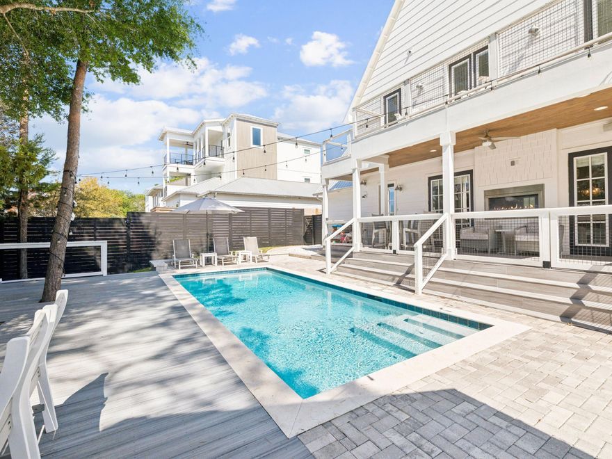 Located in the highly sought-after Gulfview Heights community on the west end of 30A, 214 Woodland Drive offers an exceptional blend of architecturally refined coastal design, prime location, and proven income potential just moments from the beach, dining, and boutique shopping. Designed to impress as both a full-time residence and high-performing rental, this 4 bedroom, 3.5 bath home is already generating strong rental income in its first year while still presenting like new. Offered fully furnished and turnkey ready, including a golf cart for easy cruising along 30A, this property is ready for immediate enjoyment or continued rental success. The private backyard is a true showpiece, featuring a resort-style pool, expansive deck, ambient string lighting, and a beautifully appointed summer kitchen, creating an elevated outdoor living experience ideal for entertaining or relaxing in style.

Inside, the home showcases a thoughtfully curated design with high-end finishes and a layout that effortlessly balances sophistication and functionality. The open concept living area is light-filled and inviting, anchored by a striking double-sided contemporary fireplace that not only adds architectural interest but provides substantial warmth. The chef's kitchen is equally impressive, featuring a waterfall-edge island, butler's pantry, premium appliances, and designer finishes that flow seamlessly into the dining and living spaces.

The main level primary suite offers privacy and convenience, while an additional first floor bedroom or office provides flexibility for today's lifestyle. Upstairs, the home continues to impress with a spacious secondary living area featuring vaulted ceilings accented with exposed beams, creating a warm yet elevated retreat. Two of the secondary bedrooms also showcase these architectural beam details, adding character and visual interest throughout the upper level. A generous landing area with built-in shelving, an adorable reading bench as well as a functional desk, offers the perfect setting for remote work or study, while the custom three-level bunk nook adds a distinctive and memorable feature ideal for guests and sleepovers. Additional bedrooms and living spaces open to a private balcony, offering a peaceful escape among the treetops.

Beloved by locals for its welcoming, family-friendly atmosphere, Gulfview Heights remains one of the most desirable communities along 30A. Whether you are seeking a primary residence, second home, or a luxury investment property, this home delivers a rare combination of elevated design, exceptional outdoor living, and effortless coastal lifestyle.