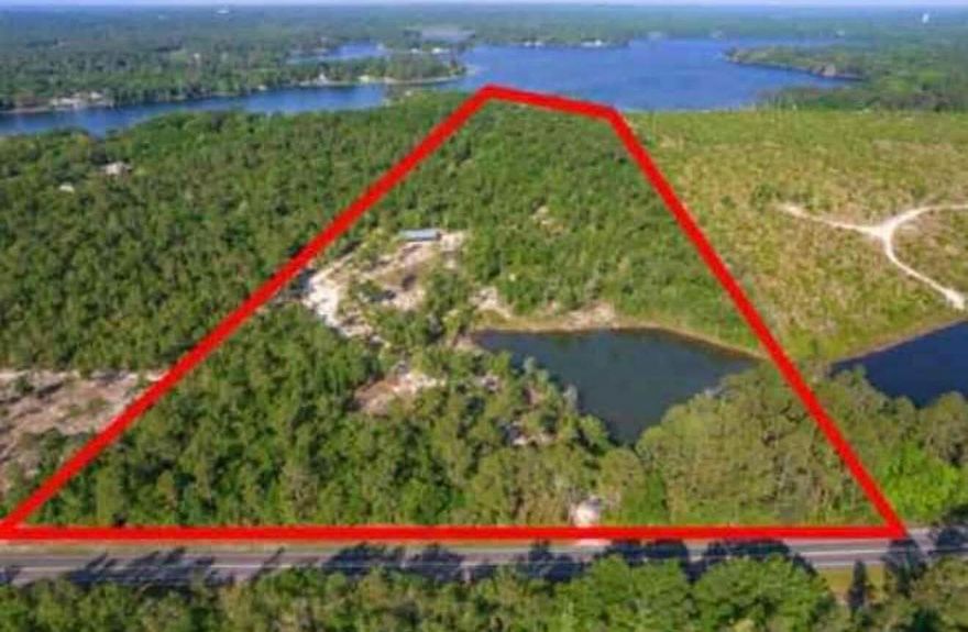 Over 31 acres with approximately 350 feet of frontage on Juniper Lake, offering a rare opportunity for expansive waterfront living in DeFuniak Springs. The property features lake frontage along Hwy 83 North and is located just 35 miles from the white-sand beaches and emerald waters of the Gulf.

Situated approximately 250 feet above sea level, this property is not in a flood zone and is positioned inland from the hurricane-prone coastline. A palm-lined entrance leads to a mature oak hammock and opens to elevated, panoramic lake views with stunning sunset vistas.

Ideal for fishing, building a private estate, or keeping for a long-term investment. A 40' x 60' newer pole barn adds immediate utility. A rare combination of lakefront acreage, elevation, and proximity to the beach!