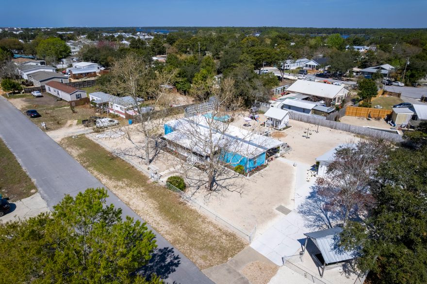 Situated on a half-acre of prime property on the desirable west end, this home is tucked away on a quiet street and offers space, privacy, and incredible outdoor living. This home features frame additions and are complemented by a detached two-car garage/workshop, while the entire property is fully fenced in.
Enjoy outdoor living at its best with nearly 1300 square feet of porch including a large covered front porch, a covered back porch, and an expansive open deck featuring built-in seating--perfect for grilling and entertaining. The backyard is designed for fun and relaxation, complete with a circular above-ground pool, and pool house.

Inside, the kitchen is equipped with stainless steel appliances ideal for cooking enthusiasts. Tile flooring runs throughout the wet areas, while the living room features durable luxury vinyl plank flooring, creating a comfortable and low-maintenance living space.