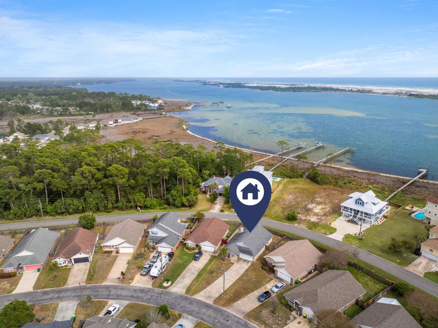 Seller offering up to $5,000 in buyer concessions with full price offer. Minutes from Hurlburt Field AFB and the sugar-white beaches of the Emerald Coast, this home blends comfort with a true coastal lifestyle. Backing to a peaceful walking path along the sound and Intracoastal Waterway, enjoy serene views and added privacy. Impressive curb appeal with extended driveway and fully fenced yard. Inside, the open-concept layout features high ceilings and a cozy fireplace. The kitchen shines with granite countertops, porcelain tile backsplash, farmhouse sink, center island, and updated appliances including a newer, gently used refrigerator. Split floor plan offers ideal separation between living and guest spaces.