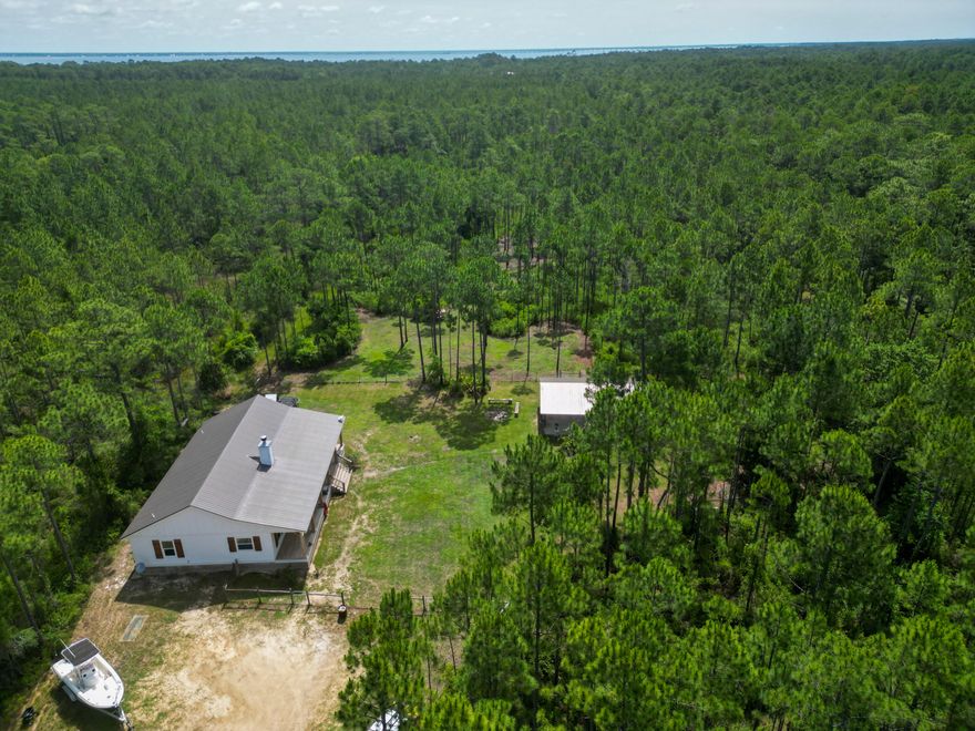 Priced $230,000 below value on appraisal and located on 10 peaceful acres in Santa Rosa Beach in South Walton County, this 3 bedroom 2 bathroom 1,870 SF secluded rustic home set well back from the road built in 2020 features a custom cypress wood kitchen island, copper sink, French doors, sprawling house-length front porch, walk-in pantry, freestanding tub, dual-head walk-in shower, and spacious walk-in master closet. plus the 10-acre property has a pole barn, a chicken pen, and a fenced yard.  Perfect for someone with pets or who loves animals as the surrounding deer and wildlife are plentiful.  This location is private and serene yet only minutes from the Gulf of Mexico, restaurants, and all the amenities that Northwest Florida has to offer.   SEE MORE... Where country serenity meets coastal living, nestled in the heart of beautiful Santa Rosa Beach, welcome to 632 N Church Street. This charming 3-bedroom, 2-bathroom farmhouse offers the best of both worlds--peaceful, private living on 10 sprawling acres, just minutes from the Gulf. Inside, you'll find rustic elegance throughout, including a custom cypress wood island and copper sink that bring the outdoors in. The master suite opens through French doors to an expansive covered porch, perfect for morning coffee or evening relaxation. The en suite bathroom features a stunning freestanding farmhouse tub, a dual-head walk-in shower, and a spacious walk-in closet.  Additional highlights include a large home office and a generous walk-in pantry perfect for anyone craving space and function.  Whether you're soaking up the sun at the beach or enjoying the sight of deer in your own backyard, this one-of-a-kind property delivers the ultimate Florida lifestyle with a countryside twist.  Seller is a licensed real estate agent in the State of Florida