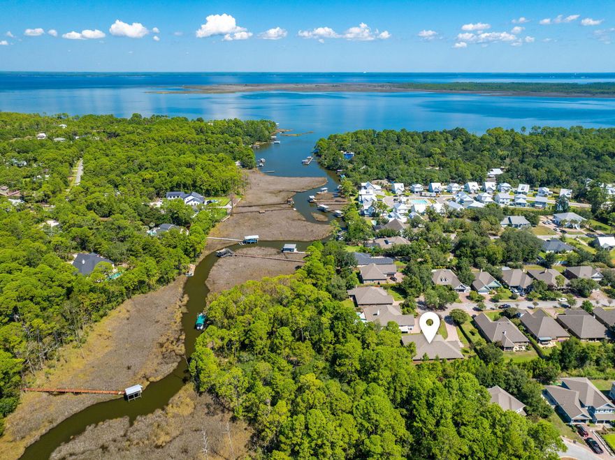 Private dock. Boat slip. Bay access. Gated neighborhood. Set on 82.5 ft of Mussett Bayou, this 5BR home offers direct access to Choctawhatchee Bay via Hogtown Bayou--spend the day at Crab Island and return straight to your own dock. Positioned at the end of a quiet cul-de-sac and backing to a protected conservation area, the setting feels private and removed. A raised walkway leads from the backyard through the preserve to the water, creating a unique, buffered connection to your dock. Inside, the open layout features a spacious kitchen with granite countertops, stainless appliances, wine cooler, and oversized island flowing into the main living area and screened lanai. The home is well-suited for both hosting and everyday living, with formal dining and a dedicated office/study, plus a split-bedroom layout that gives guests their own space without sacrificing privacy. The primary suite is positioned at the rear with direct lanai access and a spa-style bath featuring a jetted tub, tiled shower, dual vanities, and a large walk-in closet.

The outdoor experience is defined by its natural setting--step from the backyard onto a raised walkway that leads through a preserved conservation area to your private dock. From there, enjoy boating, fishing, or easy access to the bay. Spend mornings on the water, afternoons at Crab Island, and evenings back home in a setting that feels quiet and tucked away.

For buyers who value access, privacy, and a more natural setting over direct backyard exposure, this property offers a rare balance within Mussett Bayou Estates.