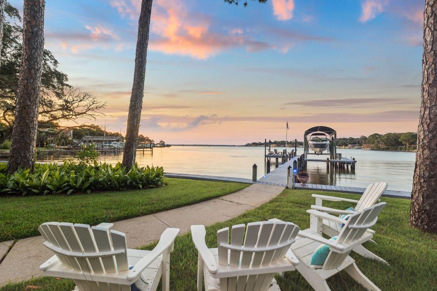 Set along 103 feet of private waterfront on the storied shores of Joe's Bayou--one of Destin's most iconic and desirable addresses. With direct access to the Gulf of Mexico just minutes away through the East Pass, and a backdrop of white sand beach, lush green space, and deepwater dockage, this estate was designed for a life well lived, and well shared. Constructed with aerated autoclaved concrete and positioned slab-on-grade, the home offers enduring strength while showcasing refined interiors and bespoke detailing. Twelve-foot ceilings, travertine floors, and a barrel-vaulted plaster entry ceiling set a sophisticated tone, while a custom kitchen impresses with Wood-Mode cabinetry, honed marble counters, a wenge butcher block island, Wolf and Sub-Zero appliances, and curated organizational features built for true chefs. The living room's wet bar, fireplace, and floor-to-ceiling windows connect effortlessly to a screened pool terrace, where views of the bayou unfold across the 90-foot private dock, 30 foot white sandy beach, and covered 30 plus foot boat slip. An outdoor shower at the dock makes rinsing off after a day on the water as effortless as the lifestyle itself. The main-level primary suite offers a sanctuary of comfort, with custom built-ins, a hidden vanity, concealed safe, and a spa-like bath wrapped in high-end quartz. A second ensuite bedroom upstairs accompanies a game and media lounge, opening to a large balcony with sweeping water views. Additional features include two additional bedrooms on the main level, a whole-house generator, tankless gas water heater, air purification system, and 2+ car garage with workspace. Just across the landscaped lawn, the second residence at 700 Beach Drive offers completely remodeled flexibility for extended family, adult children, or long-term guests, with three bedrooms and two full baths, its own driveway and a private setting. Beautifully maintained and well-appointed, it complements the waterfront home while offering its own distinct sense of space and comfort perfectly suited for multigenerational living. Together, the two homes form a rare and remarkable compound  where heritage meets modern luxury, and where every sunset over Joe's Bayou feels like it was made just for you.
