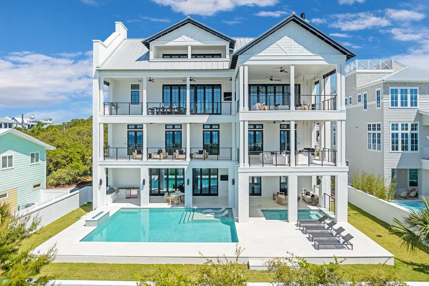 Located in the heart of Inlet Beach just moments from the Gulf and 30A, this exceptional four-level coastal residence combines luxury lifestyle appeal with proven investment performance, generating more than $512,000 in gross rental revenue during 2026, the property's first full year on the vacation rental market.

Thoughtfully designed to accommodate large groups at a luxury level while maintaining functionality and a sense of privacy throughout, the home offers more than 7,500 square feet of living space, multiple indoor and outdoor gathering areas, expansive guest accommodations, and unobstructed Gulf views from several levels.

What truly sets the property apart is the resort-style outdoor environment featuring a 30' x 26' heated pool, a 16' x 9' covered spa, outdoor kitchen, and more than 4,200 square feet of covered porches and balconies designed for seamless indoor-outdoor coastal living. The property also provides parking accommodations for at least eight full-sized vehicles and includes an elevator servicing the first three levels.

The first floor functions as a dedicated poolside living and entertainment level featuring a spacious den, prep kitchen, pool-access bath, laundry room, and a private guest suite with direct access to the covered spa and pool deck. Designed as a separate gathering environment, this level is ideal for accommodating multiple families and multigenerational groups. The second floor serves primarily as the sleeping level with six bedrooms and six bathrooms, including four Gulf-view bedrooms with balcony access. Two dedicated bunk rooms further enhance the property's functionality for luxury vacation rentals and large-group accommodations.

The third floor serves as the primary living and entertaining space, anchored by expansive open-concept living and dining areas with vaulted ceilings, a gas fireplace, full wet bar, gourmet kitchen with butler's pantry, and direct access to covered outdoor living spaces overlooking the Gulf. Designed as the social centerpiece of the home, this level creates an exceptional gathering environment for owners and guests alike.

The fourth floor features an additional oversized bedroom, rec room with built-in bunk beds, full bathroom, and access to a covered Gulf-view balcony, creating a flexible top-level retreat ideal for additional guests, overflow accommodations, or recreational use.

Whether utilized as a private coastal retreat, multigenerational family home, or high-performing luxury investment property, this residence offers exceptional scale, flexibility, and functionality in one of 30A's most sought-after beach communities.