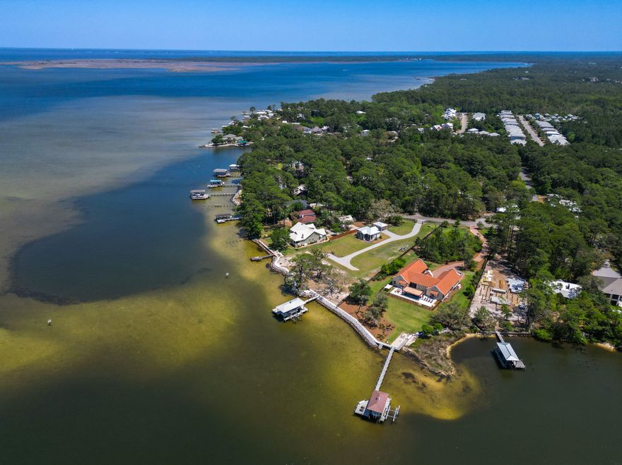Set behind a private gated entry, this exceptional 1.47-acre property on Hewett Bayou offers over 200 feet of pristine bay frontage, delivering direct deep-water access and an unrivaled waterfront lifestyle. With no HOA restrictions and the flexibility of a rare double lot, this property is ideal for boaters, nature lovers, and those seeking space and serenity along the coast. One of the last west-facing, deep-water opportunities available on the Choctawhatchee Bay, the homesite captures breathtaking sunset views across open water--an increasingly rare chance to secure a premier waterfront setting with both privacy and navigable depth. The property is thoughtfully improved with an exceptional marine infrastructure designed for both performance and longevity. The expansive dock features composite decking, a lower flow-through platform, two boat lifts, and a covered boathouse capable of accommodating vessels over 30 feet. A durable vinyl sheet seawall, reinforced with substantial riprap, provides long-term shoreline stability and protection for decades to come. The expansive grounds offer endless possibilities for a custom main residence, pool, and guest quarters, all positioned to take full advantage of sweeping water views and coastal breezes. Whether casting a line from the dock, kayaking at sunrise, or enjoying the abundant wildlife, life here moves to the natural rhythm of the bay. A charming two-bedroom, two-bath carriage house currently occupies the property with an expansive screened in outdoor living space-ideal for immediate enjoyment or as a comfortable retreat while you plan your vision for a future estate. This is more than a property--it is a rare opportunity to create a legacy waterfront compound on one of the Choctawhatchee Bay's most desirable west-facing, deep-water homesites.