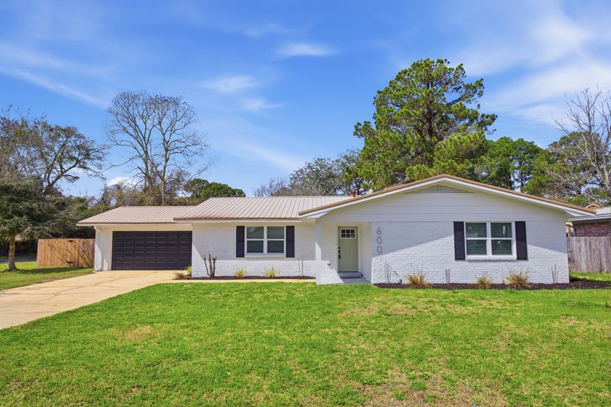 Discover modern comfort at 600 Burgundy Lane in Fort Walton Beach, where thoughtful updates and stylish finishes come together on a spacious corner lot. Inside, the home features a neutral designer color palette, luxury LVP flooring throughout, and an open-concept layout ideal for both relaxing and entertaining.

The updated kitchen serves as the heart of the home with quartz countertops, stainless steel appliances, designer lighting fixtures, and seamless flow into the living and dining areas. The living room is highlighted by a charming wood-burning fireplace, creating a warm focal point for the space.
Stylish upgrades continue throughout the home with updated bathrooms featuring tile finishes, wood vanities, and modern fixtures. Decorative, upgraded lighting add character, while new int erior paint and updated doors provide a fresh, polished look. The home also offers abundant storage with multiple closets throughout.

Step outside to enjoy the covered back porch, perfect for relaxing or hosting gatherings, along with a large powered storage shed that adds functionality and extra storage space.

Conveniently located just minutes from shopping and dining along Beal Parkway, this home is approximately 10 minutes from the white-sand beaches of Okaloosa Island and offers an easy commute to both Eglin Air Force Base and Hurlburt Field. Combining thoughtful upgrades, modern style, and a prime location, this property offers the ideal blend of comfort and convenience along the Emerald Coast.