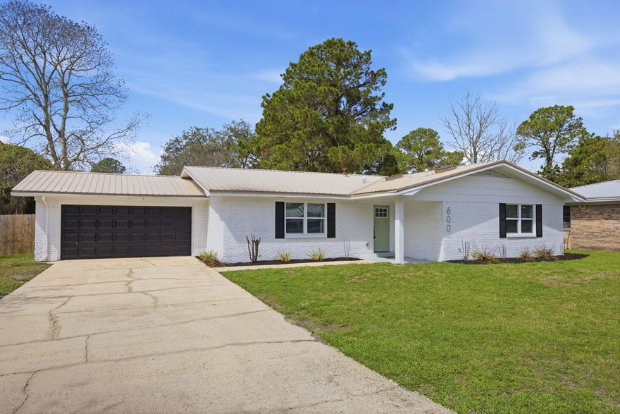 Discover modern comfort at 600 Burgundy Lane in Fort Walton Beach, where thoughtful updates and stylish finishes come together on a spacious corner lot. Inside, the home features a neutral designer color palette, luxury LVP flooring throughout, and an open-concept layout ideal for both relaxing and entertaining.

The updated kitchen serves as the heart of the home with quartz countertops, stainless steel appliances, designer lighting fixtures, and seamless flow into the living and dining areas. The living room is highlighted by a charming wood-burning fireplace, creating a warm focal point for the space.
Stylish upgrades continue throughout the home with updated bathrooms featuring tile finishes, wood vanities, and modern fixtures. Decorative, upgraded lighting add character, while new int erior paint and updated doors provide a fresh, polished look. The home also offers abundant storage with multiple closets throughout.

Step outside to enjoy the covered back porch, perfect for relaxing or hosting gatherings, along with a large powered storage shed that adds functionality and extra storage space.

Conveniently located just minutes from shopping and dining along Beal Parkway, this home is approximately 10 minutes from the white-sand beaches of Okaloosa Island and offers an easy commute to both Eglin Air Force Base and Hurlburt Field. Combining thoughtful upgrades, modern style, and a prime location, this property offers the ideal blend of comfort and convenience along the Emerald Coast.