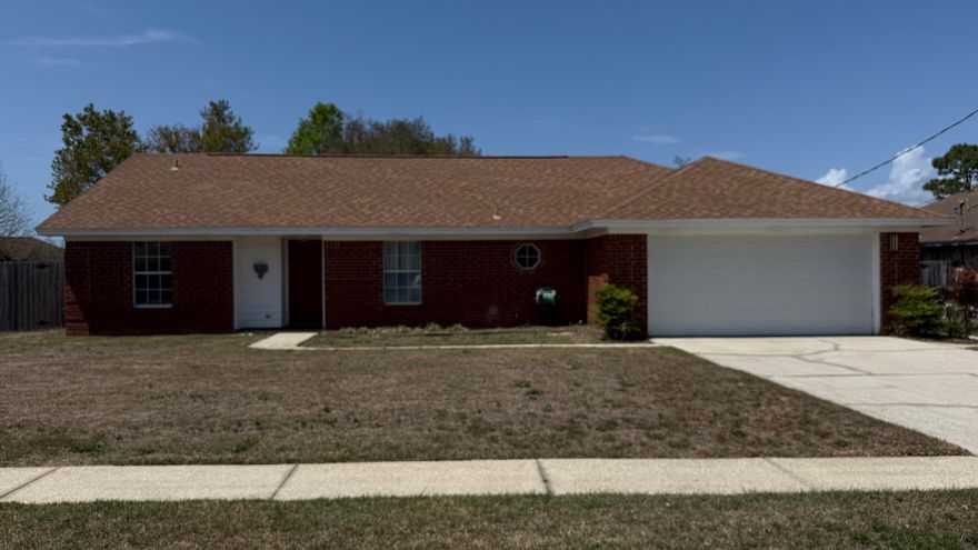 PRIME LOCATION! Ideally situated just 4 miles from the white sands of Navarre Beach and close to military bases, shopping, and dining!  This 1,656 sq. ft. brick home offers incredible value. The bright, open living area with wood flooring flows into the eat-in kitchen featuring a pantry and glass-top range. The Eat-In Kitchen has original cabinets and countertops that are clean and functional.  The primary suite boasts double vanities and an oversized tiled shower. One guest bedroom is nicely sized and the second is an impressive 24 feet long with built-in shelving and direct access to the large, screened porch - perfect for enjoying Florida's weather!  The Guest Bath has a newer vanity and the shower/tub is in excellent condition.  Outside, the privacy-fenced backyard is lush - filled with beautiful azaleas & complete with a lawn pump/sprinkler system and a sturdy storage building on a concrete foundation. Notable updates include a 2021 Rheem HVAC and a 2007 roof in excellent condition. This home is being sold AS-IS and is priced to allow for your personal cosmetic updates (flooring/wallpaper), though it is fully livable in its current state. VA buyers are welcome however, any lender-required repairs will be a buyer's expense. Don't miss this opportunity to own a charming coastal home at an affordable price--see it today!