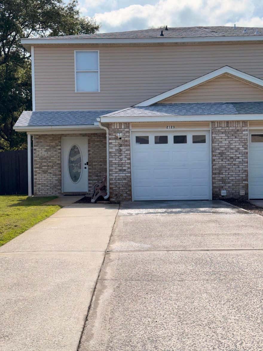 Located just minutes from Navarre Beach and approximately 7 miles west of Hurlburt Field, this well-maintained end-unit townhome offers comfort, convenience, and thoughtful updates throughout. Featuring a low-maintenance brick and vinyl exterior, the property has recently been refreshed with new interior paint, updated black hardware and light fixtures, and both Ring and Blink security cameras available for tenant use.

Inside, the home offers a functional layout with spacious living areas and quality finishes throughout. The kitchen features a breakfast bar, pantry, and a full appliance package including a refrigerator with ice maker, microwave, range, dishwasher, and garbage disposal.

The home also offers a convenient half bath downstairs just off the living room, ideal for guests and everyday convenience, along with two full bathrooms located upstairs. Flooring throughout the home includes a combination of carpet, luxury vinyl plank, and tile.

Additional features include a freshly coated one-car attached garage with automatic opener, expanded driveway parking with room for multiple vehicles, a privacy-fenced backyard with deck/patio space, and an ideal location near beaches, shopping, dining, and military bases.

If you're looking for a clean, updated rental in a highly convenient location just minutes from the beach, this property is a must-see. Pets may be considered on a case-by-case basis with owner approval and a $500 non-refundable pet fee.