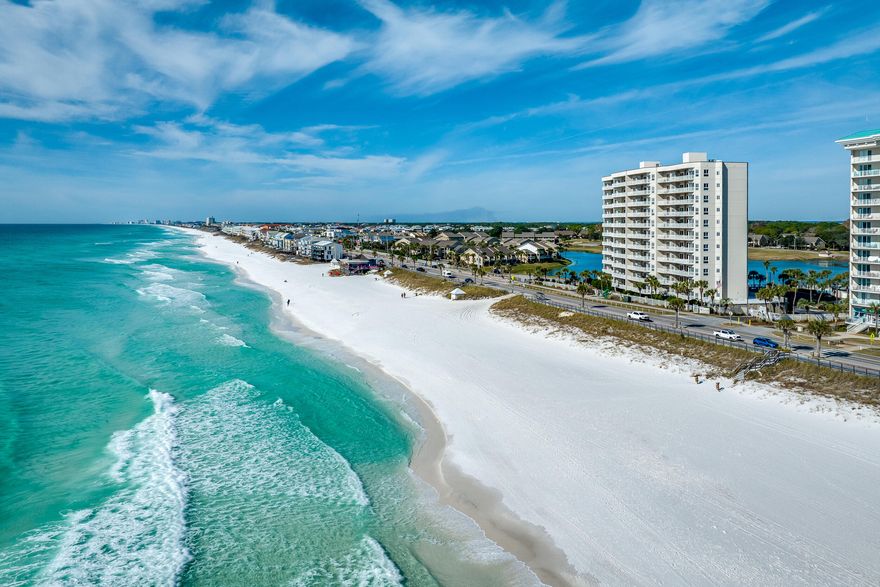 Empress 704 offers a distinctive design, breathtaking Gulf and Bay views, and a spacious layout. This unique floor plan features two living areas, 10-foot ceilings, a wet bar, and upscale yet comfortable furnishings. A 50-foot wraparound terrace seamlessly connects the open living space to the Gulf-side suites, each with terrace access and extra windows showcasing stunning views. The modern kitchen boasts stainless steel appliances and floor-to-ceiling creamy white cabinetry. The main ensuite includes a king bed and sitting area, while the newly furnished third bedroom features twin beds and a wall of windows. New LVP flooring in all bedrooms, freshly polished travertine tile in living areas, and updated ceiling fixtures throughout. Step into unparalleled coastal luxury at Empress 704.