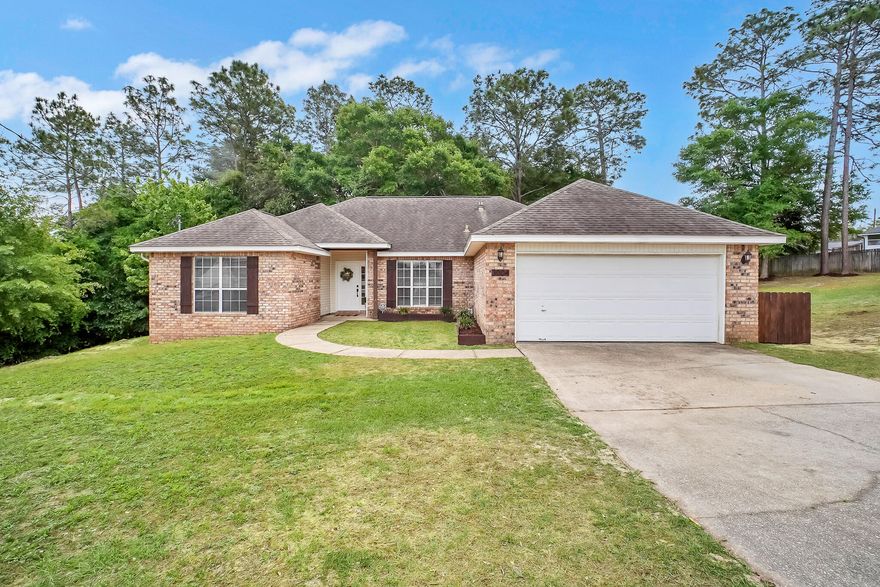 This spacious 4 bedroom, 2 bathroom brick home is situated on a 1.12 acre lot. Tucked away in a quiet cul-de-sac in a desirable South Crestview location, just off the first traffic light, it offers convenience and privacy. It is approximately 6 miles from 7th SFG/Duke Field, and 21 miles from Eglin AFB. Inside, you will find a functional split floor plan. The main living area features vaulted ceilings, LVP flooring, and updated fixtures. The kitchen is complete with granite countertops and stainless-steel appliances. The primary bathroom includes a walk-in closet, a linen closet, a separate garden tub, shower, and a private toilet room. Spend quiet evenings on the large back deck overlooking protected wetlands, offering added privacy and peace of mind with no future development behind you.