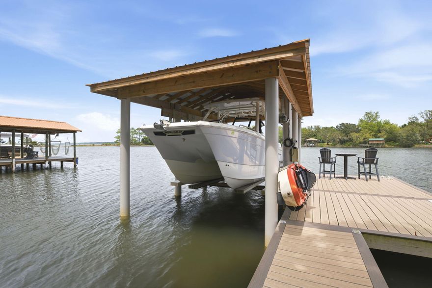 Tucked beneath a canopy of mature oak trees along the peaceful Bay location - this extraordinary waterfront residence is the definition of refined coastal living--where thoughtful design meets uncompromising quality and every detail has already been elevated for the next owner.

From the moment you arrive, the presence is undeniable. A newly completed driveway, sidewalk, and dedicated boat trailer parking pad (2023) set the tone, while the exterior showcases durable James Hardie board siding (2021), new gutters (2022), and a 30-year architectural roof (2022). Step inside and you'll immediately feel the care and craftsmanship poured into this home--every interior door, trim piece, and hardware selection has been completely updated, creating a cohesive and elevated aesthetic throughout. The heart of the home is a fully reimagined kitchen, taken down to the studs and expanded in 2022 to create a true gathering space. Outfitted with premium GE Café appliances, a Silgranite sink, soft-close cabinetry, granite surfaces, and stunning shiplap ceilings, this space seamlessly connects to a walk-in pantry and thoughtfully designed office (or optional 5th bedroom) with its own walk-in closet. The adjacent laundry room was also relocated and redesigned for maximum functionality.

Designed with flexibility in mind, the home features two luxurious primary suites--including a private upstairs retreat added in 2022 above the newly constructed garage. This suite is a sanctuary of its own, complete with a dedicated HVAC system, 50-gallon water heater, and the ability to be fully isolated from the rest of the home--perfect for guests, multigenerational living, or ultimate privacy.

Step outside and experience true waterfront living. The backyard is fully fenced (2025) with convenient dog door access, leading you to a beautifully maintained outdoor space complete with a resurfaced pool (2025), upgraded multi-stage pump, and saltwater system (2022). The composite dock (2021) and professionally constructed boathouse by Northwest Marine (2022) are nothing short of exceptional--featuring ECO piles, power and water, and a 12,000 lb lift, all set on deep water capable of accommodating larger vessels. This is a rare opportunity for boating enthusiasts seeking both function and durability.

Every major system in this home has been addressed with intention and longevity in mind. Highlights include:

High-impact hurricane windows (2022)
Complete HVAC replacement with insulated ductwork to current code (2022)
Additional 100-amp electrical service, new panels, and EV charging readiness in the garage (2022)
Full PEX plumbing conversion and new water main with protective sleeve (2022)
Whole-home water filtration system (2022)
R38 blown-in insulation for enhanced efficiency
4-zone irrigation system with private well
Additional recent updates include fresh carpet (2026), updated secondary bathroom fixtures (2026), regrouted shower (2026), upgraded sunroom ceiling (2025), and continued pest protection with a transferable termite bond through Arrow Exterminators.

Beyond the home itself, the location is equally compelling. Centrally positioned for easy access to Pensacola, Fort Walton Beach, and Highway 87 for quick interstate travel--this property offers both convenience and tranquility. With no HOA, a setting rich in natural beauty, and deep-water access that's increasingly difficult to find, this is truly a standout offering along the Emerald Coast.

This is more than a home--it's a meticulously upgraded waterfront retreat where every improvement has already been made, allowing you to simply arrive, exhale, and enjoy the lifestyle.