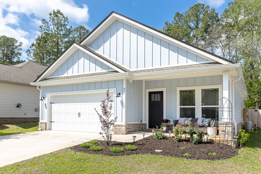 Built in 2024, this like-new home offers modern construction with thoughtful upgrades already in place. Cozy front and rear porches create the perfect setting for relaxing or entertaining, complemented by a privacy-fenced backyard, sprinkler system, and beautifully enhanced landscaping. Inside, the open-concept floor plan is highlighted by raised ceilings, recessed lighting, and LVP flooring throughout. The kitchen features a spacious work island with dining space, quartz countertops, contrasting white and black shaker cabinetry, stainless steel appliances, pantry, and a luxurious Bespoke Samsung refrigerator. The split-bedroom layout provides added privacy, with a well-appointed primary suite offering double vanities, a tiled walk-in shower with upgraded glass enclosure, a walk-in closet with custom buildouts, and a linen closet. Additional upgrades include custom closet systems in every bedroom, added kitchen shelving, new door hardware, gutters with French drains, enhanced garden beds, and a digital front door lock--making this home truly move-in ready. The neighborhood features sidewalks, a community pool, park area and a prime location with convenient access to Hwy 20 and Hwy 331, as well as the nearby Publix shopping center. Just a 20 minute drive to the beaches of 30A!