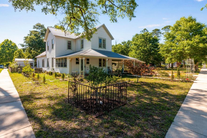 Charming historic home located in the heart of historic DeFuniak Springs, full of character, warmth, and timeless Southern appeal. Sitting on a spacious corner lot beneath mature oak trees, this inviting home features a classic wrap-around front porch, landscaped yard, and peaceful outdoor spaces perfect for relaxing or entertaining.

Inside, you'll find original charm blended with modern updates, including beautiful wood wall accents, soaring ceilings, oversized rooms, and abundant natural light throughout. The grand staircase creates a stunning focal point upon entry, while multiple fireplaces and vintage details add to the home's historic character.

The spacious primary suite offers a cozy fireplace and plenty of room to unwind, while the updated bathroom features a freestanding soaking tub with a farmhouse-inspired feel. Outside, enjoy the large back deck overlooking the backyard, mature landscaping, and additional storage buildings/workshop space.

Located just minutes from the shops, dining, parks, and lake in historic downtown DeFuniak Springs, this one-of-a-kind property offers the charm of small-town living with space and character that are hard to find.