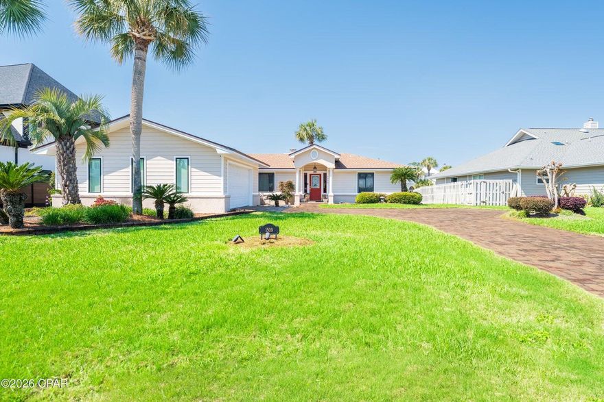 Welcome to Bay Point--one of Panama City Beach's most sought-after gated communities--where waterfront living and a true coastal lifestyle come together effortlessly. This beautifully maintained 3-bedroom, 2-bath home sits on an oversized lot with approximately 70 feet of canal frontage, perfectly positioned at the meeting of two canals, offering peaceful water views and easy access to the bay. From the moment you arrive, you'll notice the lush tropical landscaping and inviting curb appeal, along with a brick paver driveway that includes additional side parking--ideal for guests, a golf cart, or all of your water toys. Inside, the home opens to vaulted ceilings and a light-filled, open-concept layout designed for both everyday living and entertaining. The living area features a cozy wood burning fireplace, built-in entertainment center, and wet bar that flows seamlessly into the dining space--all overlooking the water. The kitchen is spacious and functional, offering ample cabinetry, generous counter space, a pantry, breakfast area, and a center island that makes gathering easy. The primary suite is privately situated and offers a peaceful retreat with a large custom walk-in closet and a dedicated office space with water views. The ensuite bath features dual vanities, a soaking tub, and a walk-in shower. One of the standout features of this home is the seamless indoor-outdoor living. The sunroom, accessible from both the living room and primary suite, opens to a spacious deck overlooking the canal--perfect for relaxing or entertaining. From there, step down to your private dock and seawall, with plenty of room for a larger boat and direct access to the bay and Shell Island. Living in Bay Point means enjoying 24/7 gated security, golf-cart-friendly streets, a Jack Nicklaus-designed golf course, full-service marina, and an on-site restaurant--all just minutes from St. Andrews State Park, the beach, and some of the area's best dining and shopping. This is what coastal waterfront living is all about--easy, inviting, and made to be enjoyed.