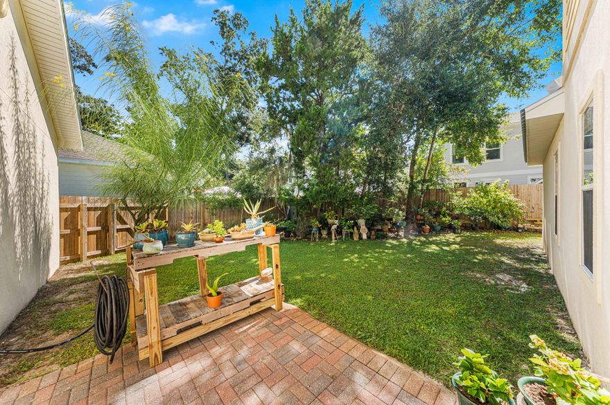 Tucked beneath a canopy of majestic oaks just steps from the bay, this beautifully crafted 4-bedroom, 3.5-bath home blends timeless Southern charm with thoughtful updates and inviting living spaces.

Step inside to discover a sun-drenched family room anchored by a cozy fireplace, where oversized windows frame views of the lush courtyard beyond. The open floor plan flows seamlessly into the gourmet kitchen, showcasing granite countertops, rich cherry cabinetry, full granite backsplash, and a breakfast bar ideal for casual meals or morning coffee. Designed for modern living, the home features two primary suites on the main leveloffering exceptional flexibility for multi-generational families or guests seeking privacy. The luxurious primary retreat includes a double vanity, jetted soaking tub, and separate walk-in shower. Upstairs, two additional bedrooms share a full bath, both featuring charming Juliette balconies perfect for savoring morning breezes.

Quality craftsmanship shines throughout: a solid mahogany front door, crown molding, classic Bermuda shutters, and a new metal roof ensure both beauty and durability. Outside, the property truly captivates with professionally landscaped grounds, a fenced backyard, and a New Orleans-style gated courtyard complete with fountainan enchanting space for al fresco dining or quiet relaxation.

The generous lot provides room to roam, while the two-car garage features a separate workshop and walk-in attic storage for all your needs. Nestled near Mack Bayou, this peaceful retreat offers Old Florida tranquility yet remains minutes from Ascension Sacred Heart Hospital, Grand Boulevard's vibrant shopping and dining and the sugar-white beaches of the Emerald Coast.