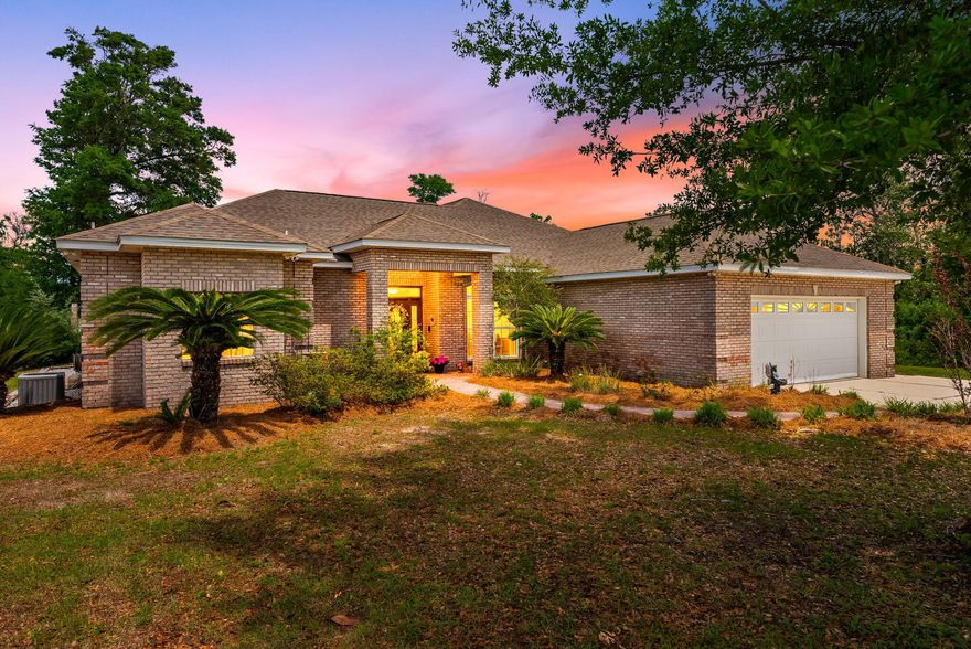 OPEN HOUSE 5/16 1-4PM This exceptional home sits on 2.66 acres of direct Deerpoint Lake frontage in Bay County, Florida. Updated in 2017 and in excellent condition, it offers a rare combination of modern finishes, serious outdoor entertaining space, a detached garage, and a private boat dock.
The paved circle driveway with tall covered parking accommodates a boat, RV, or extra vehicles with ease. Brick construction and vinyl trim keep maintenance minimal -- a detail you'll appreciate before you even step inside. Inside, high ceilings and quality ceramic plank flooring set the tone throughout. Click ''more'' A formal dining room and ornate dry bar anchor the open floor plan, which flows naturally into a family room and adjacent sitting area centered around a large wood-burning fireplace -- both overlooking the incredible outdoor entertainment area beyond.
The peninsula kitchen is clean and modern: granite countertops, stainless appliances, and a Jenn-Air cooktop with built-in oven and convection microwave. The primary suite was fully enhanced in 2017 with an additional dedicated A/C unit, dual vanities, a tile rain shower, an alcove soaking tub, and a private toilet and bidet. The 2017 renovation also created a second primary bedroom -- a generous 12x22 with twin closets and its own bathroom. A Maytag washer and dryer convey with the home. The finished, oversized attached double garage connects directly to the kitchen for everyday convenience.
Outside, the east side of the property remains wooded for privacy. A 30x40 detached garage with high ceilings, LED lighting, and ceiling fans has been built out as a serious workshop -- wired with multiple 220V circuits for an RV connection, compressor, or welder. Paver parking extends along two sides. Behind the home, a 45x52 paver entertainment area features a built-in brick and stainless grill and a large stone fire pit. An electrical stub-out and outdoor shower are already in place for a future pool.
Down at the water, a private dock and covered 16x20 boathouse await. The property runs on a 4-inch well with a dedicated well house and filtration system serving the home and two irrigation zones. Septic and drain field eliminate city water and sewer costs entirely. No HOA. Flood Zone X -- no flood insurance required.