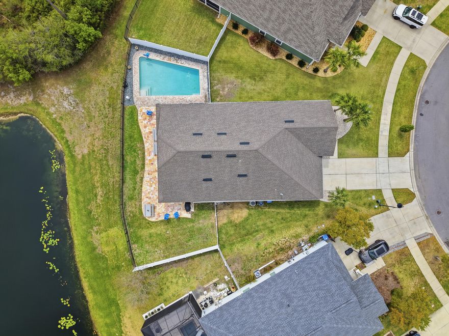 MOTIVATED SELLER - OFFERING $20,000 CONCESSIONS WITH AN ACCEPTABLE OFFER! Waterfront home in Breakfast Point offering approximately 3,200 sq. ft., 4 bedrooms plus a bonus room that can function as a 5th bedroom, and a fully fenced yard with a saltwater pool. Interior features include hardwood floors, high ceilings, formal living and dining area with built-in shelving, and a split-bedroom floor plan. The kitchen opens to the main living area overlooking the pond and includes granite countertops, stainless steel appliances, dual industrial refrigerators, a large kitchen island, pantry, built-in desk/workspace, and a reverse osmosis water filter at the kitchen sink. The primary suite is located off the main living area and includes pond views, double vanity, tile walk-in shower, soaking tub,  full bath, and the walk-in laundry room offers extensive shelving. The upstairs bonus room includes a half bath and can serve as a media room, office, or additional bedroom. Exterior features include a covered tiled patio, paver pool deck, vinyl privacy fencing, and iron fencing along the pond. Pond is catch-and-release with some good-sized bass. All sizes and measurements are approximate and should be verified if important. Some photos are altered or staged using AI for conceptual purposes. Conveniently located within walking distance to Breakfast Point Academy and near shopping, restaurants, Home Depot, the Breakfast Point sports complex, and approximately 2 miles to the beach.