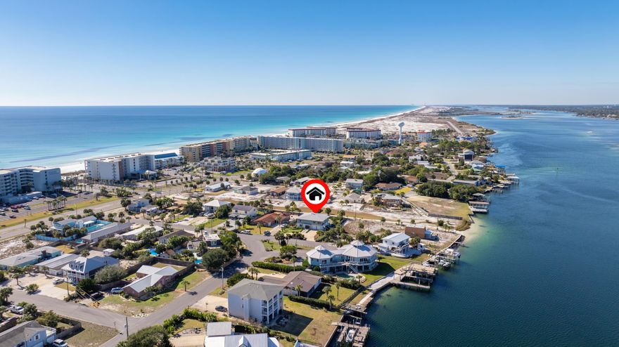 Water views. Steps to the Sound. Moments to the Beach. A thoughtfully designed mid-century, coastal home on highly sought-after Okaloosa Island. Located just steps from direct Intracoastal Sound water access and a short 3-minute walk to Public Beach Access 6, 721 Sailfish Drive offers an exceptional Florida coastal lifestyle centered on water, light, and livability. This expansive 5-bedroom, 3-bath home features Sound views, a remodeled atrium space, and enclosed sunrooms with oversized front-facing windows that bring in abundant natural light, including a cardio/fitness room and a coffee bar with water views.

The open floor plan is designed for both everyday living and entertaining, highlighted by two elegant double-flue fireplaces with white marble rock surrounds that add warmth and architectural balance. A redesigned floating staircase with custom iron detailing creates a strong first impression, complemented by Vermont slate tile, newly installed LVP flooring (2025), cypress wood walls, new lighting and ceiling fans, and custom window treatments.

The updated kitchen includes brand-new stainless-steel appliances (2024), a double pantry, breakfast bar, eat-in dining area, vast water views and seamless flow into the main living spaces. The primary suite is a true retreat, offering Sound water views, private access to a covered deck, a cedar-lined walk-in closet, and a fully renovated ensuite bathroom with a custom tile walk-in rain shower, frameless glass door, LED backlit mirror, and upgraded fixtures.

Two distinct levels of living space provide flexibility for entertaining, hosting, or multigenerational living, with a lower-level living area and wet bar with kitchenette components that work well for guests or in-laws. Outdoors, the home offers a fenced-in oversized pool, covered patio, expansive back deck with screening potential, outdoor shower, and newly installed St. Augustine sod (2025). Elevated at 12'6" above sea level, the home offers peace of mind while delivering a lifestyle tailored for beach lovers, entertainers, and families seeking water views and effortless Gulf access.