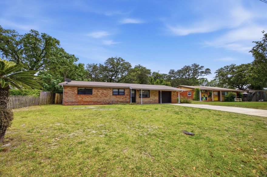 Located between Hurlburt Field and Eglin Air Force Base, 134 NW Virginia Drive puts daily commuting and city access at the center of convenience. Less than a mile from Beal Parkway and Mary Esther Cut Off, you have direct access to Publix, Walmart, Sam's Club, Home Depot, Lowe's, Aldi, restaurants, and everyday shopping without fighting long traffic patterns across town. Public parks, schools, and daily essentials are all nearby. The property is also approximately 15 minutes from the beaches of Okaloosa Island and about 20 minutes from Destin-Fort Walton Beach Airport, making travel, beach days, and weekend plans easy to navigate.

Inside, the layout offers 3 bedrooms and 2 bathrooms with additional functional living space that gives flexibility for a designated dining room, second sitting area, office setup, or extended entertaining space. There is also room adjacent to the kitchen for a breakfast table or casual dining area.

Recent updates include a newly tiled kitchen, renovated bathrooms, new carpet, new ceiling fans, and a new hot water heater. The Florida room has been recently rescreened, and the covered back patio off the laundry room is set up well for grilling, outdoor seating, or even a spa setup.

The oversized fully fenced backyard is one of the standout features of the property, offering mature trees, added privacy, and a fruit tree already in place to enjoy.

Move-in ready and priced to sell, this home offers updated condition, practical space, and one of the most convenient locations in Fort Walton Beach for daily living and commuting.
