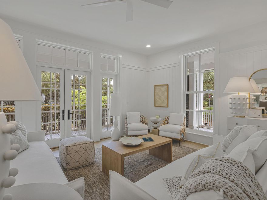 Completely and thoughtfully renovated, this exceptional five-bedroom, five-bath residence in Phase Three of WaterColor blends timeless coastal architecture with refined, modern updates. Enhanced beyond its original footprint, the home offers improved livability, beautifully refreshed interiors, and elevated finishes just steps from the Frog Pond Pool and park.

Positioned on a desirable corner lot, the property features over 1000 square feet of screened porches, creating seamless indoor-outdoor living. A charming paved path leads to the welcoming front porch, an ideal setting for relaxed mornings and sunset conversations. Inside, the light-filled sitting room flows effortlessly into an elegant dining space complete with a wet bar, buffet, and built-in wine cooler. Walls of windows and French doors illuminate the hardwood flooring and highlight the home's airy, open-concept design perfectly suited for entertaining and multi-generational gatherings.

The fully renovated kitchen is both sophisticated and functional, appointed with crisp white cabinetry, quartz countertops, stainless steel appliances, generous storage, and an oversized island with bar seating. A nearby side porch provides an intimate setting for alfresco dining.

The first-floor primary suite offers comfort and convenience with a spacious, spa-inspired bath featuring dual vanities and a soaking tub. Upstairs, beneath vaulted rooflines, you'll find a charming bunk room and two well-appointed ensuite bedrooms. A second-floor screened porch overlooks the peaceful, tree-lined streetscape, an inviting retreat for coffee or a quiet read.

A separate staircase leads to the private carriage house above the two-car garage, offering a spacious guest suite with room for a king bed and twin bunks, a sleek full bath, and a cozy sitting area ideal for guests or continued rental flexibility.

Complete with an attached garage and ample parking in the paved courtyard, residents enjoy access to miles of scenic trails and boardwalks, pocket parks, resort-style pools, and the coveted amenities that define the WaterColor lifestyle.