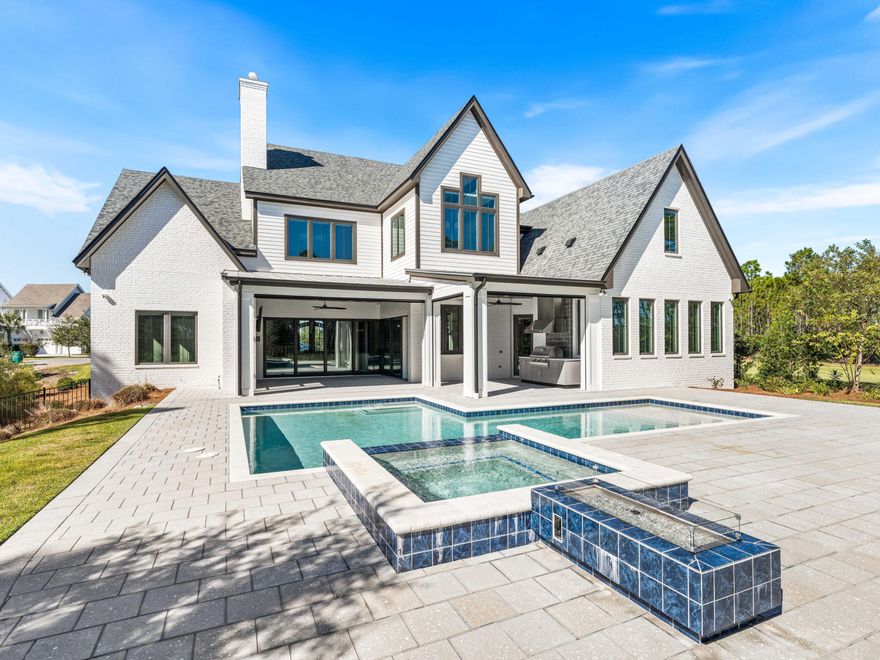 Elegance radiates from every corner of this spectacular property positioned on an almost half-acre homesite in the premier coastal community of Watersound Camp Creek. The residence encompasses 5,501 square feet with 5 bedrooms, 6 full baths plus heated swimming pool and spa and incredible outdoor living area.
From the moment you enter the grand foyer, notice meticulous attention to detail and designer lighting throughout. The first floor offers an open-concept kitchen, and dining area with hardwood floors, custom built-ins, and a stunning linear fireplace as the focal point of the main living space. The exquisitely appointed kitchen features a large center island, commercial-grade stainless steel appliances with a six-burner range and skillet, and custom cabinetry.  NanaWall sliding doors open directly to the outdoor kitchen, making the line between inside and out seamless. A hidden scullery offers a second refrigerator, dishwasher, sink, and ample pantry storage.  A 200+ bottle wine room and a dedicated wine cooler in the dining area round out an entertainer's dream. An integrated Sonos sound system runs throughout the home.

The outdoor living area features retractable motorized screens, a summer kitchen, fireplace, and generous seating -- all opening to the heated pool, spa, and enormous backyard that fronts a dedicated wooded area.

The first level also includes a full bath, laundry and sand room with built-in storage, and a guest bedroom with ensuite. The primary suite features a tray ceiling, a luxurious ensuite with raised ceilings, opulent tile accents, soaking tub, large shower, an expansive walk-in closet, and a dedicated safe room.  Upstairs, the secondary living area with wet bar is expansive enough for a game room, home theater or golf simulator. Three additional ensuite bedrooms complete the second level.

Owners of Watersound Camp Creek enjoy an exclusive level of membership to The St. Joe Company's Watersound Club. This membership conveys at closing and entitles them direct access to the club amenities at Camp Creek, including resort pools, an 11,000 square foot fitness center, tennis and pickleball courts, multiple private dining venues, and a Tom Fazio-designed golf course. Additional member benefits include complimentary gulf-front chair and umbrella service at the Watersound Beach Club. Members also enjoy golf at the private Shark's Tooth course at Wild Heron and The Third, the club's newest course.