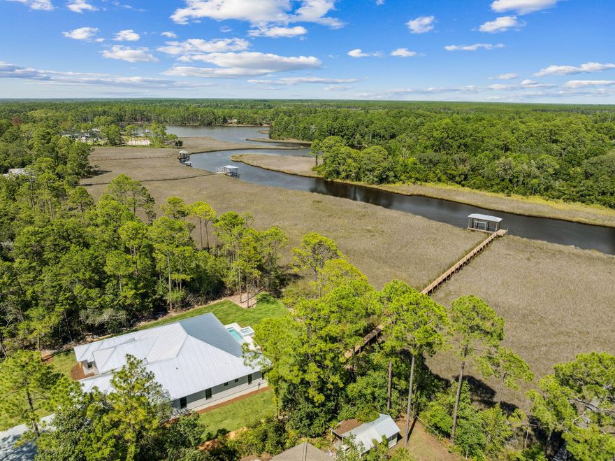 Welcome home to waterfront living on Eden Drive. This brand new, custom single-story home is situated on a private, half acre lot, including 4 bedrooms, 4.5 baths, a 3-car gar-age, boat dock and slip, and every amenity a family could desire. Delight in panoramic bayou views as you enter the home into a recessed foyer, the perfect space to feature artwork and welcome guests into your home. Designed with timeless finishes and thoughtful details, this residence features saddle brown stained oak floors throughout. The open concept living room boasts cypress accent coffered ceilings, a gas fireplace, and wet bar with wine and beverage center, creating the ideal entertainment space. Your stunning view is uninterrupted as you continue into the kitchen, showcasing an expansive Taj Mahal granite waterfall island with porcelain apron sink and antique gold bridge faucet. Preparing meals in this kitchen won't be a chore with a Butler's Pantry, Cafe 6-burner gas stove and double refrigerator/freezer. Just adjacent to the kitchen is a dedicated office space and additional storage with built-in desk and shelving. Step through full glass sliding doors to an expansive outdoor retreat. Enjoy your summer days and nights in your own backyard -- complete with covered patio, gas fireplace, outdoor kitchen, pool with sun-deck and hot tub, firepit, and a private dock and boathouse. With direct access to the In-tracoastal waterway and Choctawhatchee Bay, whether you plan to boat to dinner at The Bay or North Beach, or explore further to Destin Harbor and Crab Island, your boating options are endless right from your dock. The waterside master suite includes his and her closets, a soaking tub, and double shower for spa-like comfort. The three additional bedrooms offer ensuite bathrooms with custom tile finishes. The exterior of the home fea-tures artisan board siding, stucco accents, full glass steel front doors, and gas lanterns, portraying elevated Southern charm with modern luxury in Point Washington.