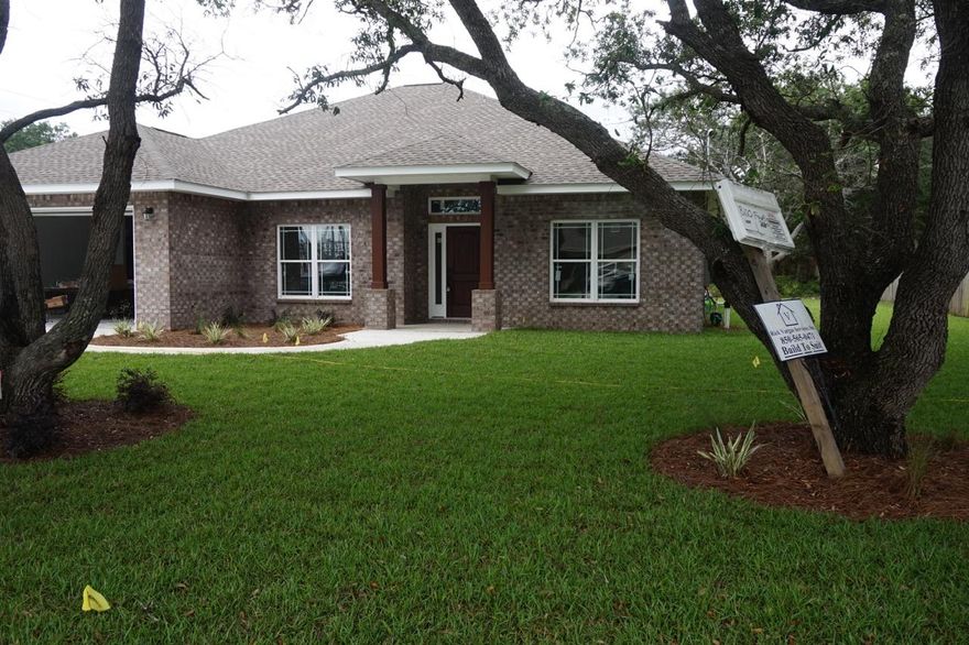 NEW CONSTRUCTION in East Navarre~ Luxurious 4 bedroom / 2 bath split floor plan is completed and move in ready..Wonderful curb appeal on a beautiful oak tree lot and within walking distance to the Waterfront Navarre Park ,Beach Bridge,local stores and schools~All brick exterior with accent craftsman columns and huge covered back porch. Impressive inside and out with custom attention to detail~Soaring 11 ft Trey ceiling with archways and sweeping nooks in the main living area. Large kitchen with custom staggered cabinets/ crown, under mount sink,extractor hood~S/S appliances and beautiful 3cm granite counter tops~ wrap around hop up bar with open flow to the Great Room with French doors out to the Huge 22 x 10 ft. covered back porch with TV sockets to have a complete outdoor living space to sit and enjoy those wonderful Florida evenings.
Greeted by the 8ft wood door ~opening to the entrance foyer with engineered Wood  flooring~ open flow through to the great room and sweeping arch to the formal dining ~ large tile in the kitchen and all wet areas. Great size Master with Trey ceiling~ his and hers walk in closets ~Large corner custom walk in shower with fixed and hand held shower heads,granite double vanity ,antique bronze fittings~ separate WC ~ deep soaking tub. Additional bedrooms are carpeted, good size rooms with large closets and ceiling fans,additional bath has step in tub/shower,large vanity area with drawers.Separate laundry room with  drop sink ,oversized double garage 20x21with drop down stairs ~50 gallon Water heater.Home is situated on a large lot with grassed yard ( approx. 50ft off back porch )~Well and irrigation system for easy maintenance in the summer months, wonderful oak trees & large existing shed that can convey AS -Is.Home is also set to allow a large west access to the back yard that could accommodate a boat or RV Hurricane window protection and Not in a flood zone for  affordable home insurance~ short driving distance to Hurlburt. Call today to get further details on this gorgeous custom built home.
