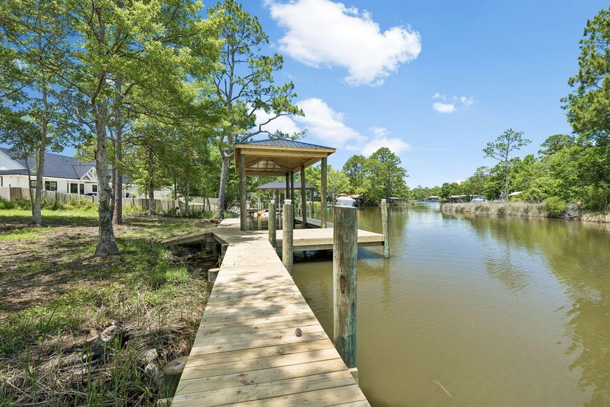 Discover the perfect canvas for your coastal dream home on this exceptional canal front lot just outside the Freeport city limits. Ideally positioned only 10 minutes from the world renowned Beaches of South Walton, this rare offering combines peaceful waterfront living with unbeatable convenience. Spanning just over a half acre, the property provides direct access to Mallet Bayou and seamlessly connects to the Choctawhatchee Bay, offering endless opportunities for boating, fishing, and exploring the gulf waters beyond the bay. A new boathouse with additional dock space are already in place, providing immediate functionality and added value for water enthusiasts. The Choctawhatchee Bay, a stunning 30 mile estuary stretching across Okaloosa and Walton counties, is fed by the Choctawhatchee River and opens to the Gulf of Mexico through the Destin East Pass, making this location a true gateway to some of the Panhandle's most sought-after waterways. Whether you're envisioning a private waterfront retreat or a full time residence, this property delivers the ideal balance of seclusion and accessibility, tucked away in a serene setting while still just minutes from shopping, dining, schools, and the sugar-white sands of the Emerald Coast.