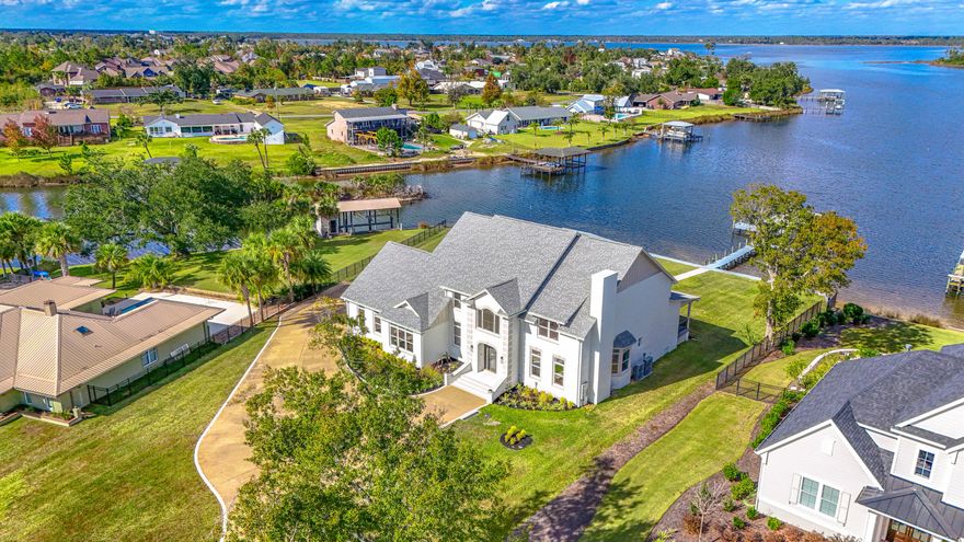Completely renovated down to the studs, this luxurious two-story residence has been reimagined with uncompromising quality and high-end finishes throughout. Situated on a .89-acre lot with approximately 210 feet of deep-water frontage on Mill Bayou, providing direct access to North Bay and the Gulf of Mexico, this property offers an exceptional coastal lifestyle. Enjoy evening sunsets around the gas firepit, relax on the brick-paved patio, and follow the walkway to your private dock and boathouse for quick access to boating and fishing. From the moment you arrive, the home's elegance is undeniable. Step into the impressive two-story foyer with 19-foot ceilings and immediate sightlines through the expansive living room to the water beyond. The living room features a gas fireplace, wet bar with wine cooler, and direct access to the 58-foot covered rear porch, an ideal space to enjoy morning coffee or an evening glass of wine. A den with a gas fireplace sits to the right of the foyer, and a conveniently located powder room is just off the main living area. To the left is the formal dining room, a full bath, and a well-appointed laundry room with Cambria quartz countertops, sink, and abundant cabinetry. The kitchen is a chef's and baker's dream, equipped with premium Thermador appliances, including a custom range hood, Cambria quartz counters and island, tongue-and-groove pine ceilings, tile backsplash, kettle faucet, and a custom walk-in pantry with water and electrical connections for an additional refrigerator. The breakfast area and adjoining living space provide breathtaking panoramic views of the bay. The oversized 3-car garage (37.9 feet deep) accommodates multiple vehicles, storage, or a golf cart. The home is thoughtfully designed with handicap-accessible features, including ramps along the left side into the garage and from the home to the outdoor entertaining area and dock. Two additional main-level bedrooms are located on the right side of the home, one offering beautiful water views. They share a spacious Jack-and-Jill bath with a tiled glass shower and dual vanities. For added convenience, the home provides two staircases, one off the foyer and one at the rear. The second floor showcases an extraordinary primary suite measuring approximately 29' x 15', complete with a sitting area surrounded by windows overlooking the bay. A barn door opens to the luxurious primary bathroom, where no detail has been overlooked: extended Cambria quartz double vanities, abundant storage, a stunning 90-gallon clawfoot soaking tub with water views, an oversized tiled shower with dual showerheads, separate water closet, linen closet, and a utility closet with space for a stackable washer/dryer (in addition to the main downstairs laundry). The double walk-in closet consists of two custom-designed rooms with extensive shelving and cabinetry. Pull-down attic access offers even more storage. The second level also includes four additional bedrooms, two on each side of the home, each pair connected by a Jack-and-Jill bathroom. In total, the home offers 7 bedrooms, 5.5 bathrooms, and 5,522 heated and cooled square feet (per appraiser).Additional Features Include:" Seawall" Circular driveway" COREtec VP flooring throughout (with tile in select areas)" Four HVAC units (two double-stacked systems) with separate upstairs/downstairs controls" Culligan water filtration system" Visual Comfort lighting" Crown molding in foyer and family room" High-profile baseboards and soft-close cabinetry throughout" Two electric forced hot-water units" Raised cable outlets, timer outlets, and USB outlets" Open-cell insulation in walls and ceilings for energy efficiency.  This exceptional property must be seen in person to fully appreciate the craftsmanship, thoughtful design, and luxurious coastal setting. Contact your Realtor today for a private showing before this piece of paradise becomes someone else's reality. Age, square footage, schools, taxes, room dimensions, and any important information are estimates only and should be verified by the buyer through personal or professional inspections.