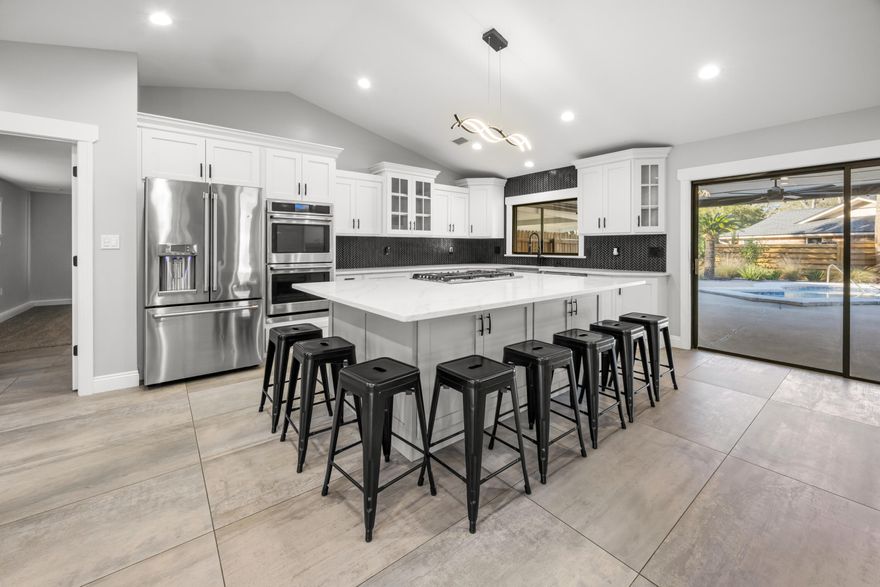 **$10,000 ANYWAY money!!**DESIRABLE Kenwood subdivision** UPDATED 4-bed, 2-bath home offers OPEN-CONCEPT living & VAULTED ceilings & FIREPLACE as the family room centerpiece. The FULLY RENOVATED kitchen features custom WHITE SHAKER cabinets, an oversized ISLAND, and GE Café appliances including a SMART double oven, SMART French-door refrigerator, 36-inch 5-burner GAS cooktop with downdraft, and built-in microwave. A pass-through window opens to the OVERSIZED covered patio for easy entertaining. The landscaped backyard includes a resurfaced GUNITE SALTWATER pool (2025) with new light, pool pump (2023), patio, TURF play area, and canine corner. Major upgrades: ROOF 2021, HVAC 2021 with dehumidifier, FULL REWIRE 2021, new FENCE 2022, whole-house GENERATOR new carpet, propane line for future gas fireplace or outdoor kitchen, and double gate with gravel parking for boats or toys