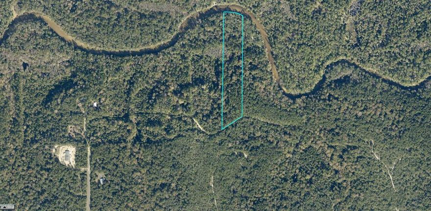 Large 7.89 acre, secluded, wooded lot on this beautiful, natural and private paradise bordered by the Shoal river at the back of the property. Majestic oaks, flowering Magnolias, towering Sweet bay, and many more in this forested landscape.