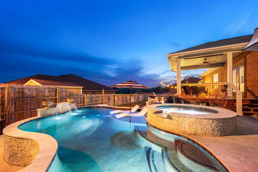 Set on a large 1/3 acre corner lot, this exceptionally maintained one-owner residence pairs classic all-brick construction with the kind of backyard experience that tends to steal the show. With a saltwater pool and heated spa, expansive travertine patio, bistro lighting, a generous deck and multiple seating areas, the outdoor living is as inviting by day as it is at sunset. Inside, the open floor plan is both comfortable and polished, anchored by a spacious family room with a tray ceiling and windows to the backyard. Arched openings and bullnosed granite countertops soften the main living and dining areas, while upgraded LVP flooring and stainless steel appliances bring a current finish to the home's thoughtful design. The kitchen is well equipped for everyday living and easy entertaining offering custom cabinetry and matching island, 20-inch tile, a pantry, breakfast bar and side-by-side refrigerator. Just beyond, the covered back porch extends the living space outdoors, while the covered front porch adds another welcoming place to sit and unwind. The primary suite features a tray ceiling, along with a spacious en-suite bath complete with double vanities, a garden tub, and a separate shower. Three additional bedrooms and a desirable split floor plan provide flexibility for guests, while an added office nook creates room for work, study or household organization. Both baths include granite countertops and custom cabinetry, and Cat 6 Ethernet in all bedrooms adds a practical, modern touch. A side-entry two-car garage with a large walk-in attic above, sprinkler system, professionally landscaped yard and 2025 water heater round out the home's long list of upgrades. Residents also enjoy neighborhood amenities, including a community pool and playground, adding even more appeal to this well-kept property.