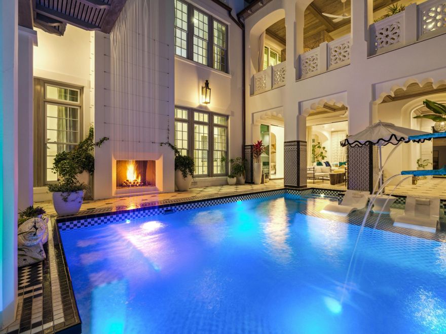 This exceptional residence offers an elevated take on coastal living, thoughtfully designed for both refined entertaining and effortless everyday comfort. A cohesive vision, curated with global influences, brings depth and character to each space, creating a home that feels both sophisticated and inviting. At its center, the kitchen is a true focal point, featuring custom wood cabinetry, a striking blue-and-white tile backsplash, and a suite of premium appliances, setting the stage for both casual gatherings and elevated culinary experiences. The expansive island, complemented by sculptural seating, creates a natural connection between the living and dining areas, encouraging a seamless flow throughout the home. The home is complemented by custom Karpaty cabinetry and a carefully curated selection of designer furnishings, including pieces inspired by and sourced through Melanie Turner Interiors and Kelly Wearstler furnishings, adding depth and sophistication throughout.

Outdoor living is equally compelling, with two resort-style pools and hot tubs designed for both relaxation and entertaining. The central courtyard serves as a private sanctuary, framed by intricate tilework and elegant archways, and enhanced by an integrated bar and grilling area--an ideal setting for quiet moments or lively gatherings.

A charming casita offers a private retreat for guests, complete with a bedroom and full bath, allowing for comfort and privacy while remaining connected to the main residence. Expansive nano doors open to a beautifully integrated outdoor living space, creating a seamless transition between indoor and outdoor environments.

The rooftop level provides an additional layer of luxury, featuring a heated pool, fire pit lounge, outdoor bar, and grilling station, all set against sweeping views of Alys Beach. The owner's suite is a tranquil retreat, enhanced by custom mural work and a spa-inspired bath with refined finishes and a sculptural soaking tub. A private office, positioned just off the balcony, offers a quiet space with serene courtyard views.
Two additional guest bedrooms with en-suite baths are located on the second floor, one featuring a Juliet balcony overlooking the courtyard. An elevator provides convenient access to all three levels, enhancing the home's livability.

Thoughtfully designed with both form and function in mind, the residence includes ample storage, a well-appointed layout, and discreet luxury throughout. Additional features include DensArmor Plus mildew-resistant drywall, a hidden whole-home surround sound system, and bespoke lighting. Dedicated parking for two vehicles is provided in a rear motor court.

Ideally positioned near Palmera Park, Caliza Pool, and Gulf Green beach access, the home is just a short stroll to the owners' Beach Club, offering effortless access to the white sands and emerald waters of the Gulf.