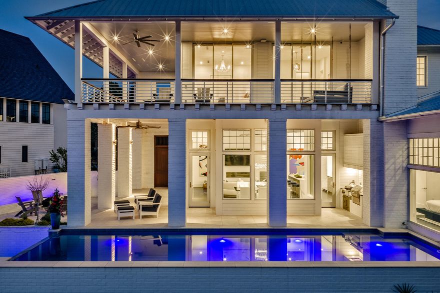 Located in the prestigious gated waterfront community of Churchill Oaks, this amazing contemporary home offers 4 bedrooms and 4.5 bathrooms plus a custom bunk room.  Positioned to capture the expansive bay views and backing to a conservation preserve, the property provides exceptional privacy.  Features include two primary suites, three laundry rooms, ceramic tile flooring, a walk-in climate controlled wine room and a steam shower.  The chef's kitchen is equipped with premium Miele appliances, custom cabinetry and designer lighting.  Outdoor living includes a negative edge pool and fire pit, ideal for enjoying the waterfront setting.  The property also includes a 50 FOOT BOAT SLIP making it ideal for boating enthusiasts. A beautifully designed carriage house above the garage, is complete with a private entrance for added flexibility and privacy.  Connected to the main residence by a charming breezeway, the space is ideal for guests and extended family. The carriage house features a mini kitchen, and it's own washer and dryer, creating a functional and comfortable separate living area.  Churchill Oaks includes an expansive bayfront clubhouse, marina and walking paths.