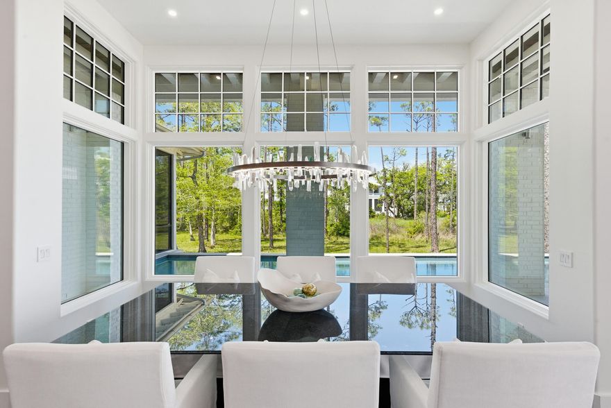Located in the prestigious gated waterfront community of Churchill Oaks, this amazing contemporary home offers 4 bedrooms and 4.5 bathrooms plus a custom bunk room.  Positioned to capture the expansive bay views and backing to a conservation preserve, the property provides exceptional privacy.  Features include two primary suites, three laundry rooms, ceramic tile flooring, a walk-in climate controlled wine room and a steam shower.  The chef's kitchen is equipped with premium Miele appliances, custom cabinetry and designer lighting.  Outdoor living includes a negative edge pool and fire pit, ideal for enjoying the waterfront setting.  The property also includes a 50 foot boat slip making it ideal for boating enthusiasts. A beautifully designed carriage house above the garage, is complete with a private entrance for added flexibility and privacy.  Connected to the main residence by a charming breezeway, the space is ideal for guests and extended family. The carriage house features a mini kitchen, and it's own washer and dryer, creating a functional and comfortable separate living area.  Churchill Oaks includes an expansive bayfront clubhouse, marina and walking paths.