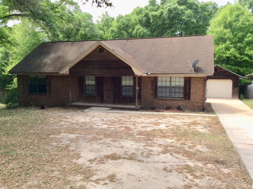 Country Living at its BEST. Rural and retro brick and cedar home with a detached garage. This home is set back from the road and offers a private rustic setting. It has a .large yard with shade trees, a small back deck and a covered front porch, The house offers the comfort of a split bedroom floor plan, a living room, a large kitchen with ample cabinets and a dining room.  The large laundry room has access to the deck and backyard. Easy for children to pop out to play and for access to the BBQ grill.  Don't be deceived by the square footage - this home lives larger. Bring a paint brush and some fresh ideas for your own color palette. Bob Sikes elementary School is a short distance away and many newer facilities are located in this northern Crestview area.  Enjoy mornings and evenings..... on the back deck or front porch.  You will be happy to be home. The new by-pass will open soon to allow a better commute to Eglin AFB 7th Special Forces and Hurlburt Field for military bases.