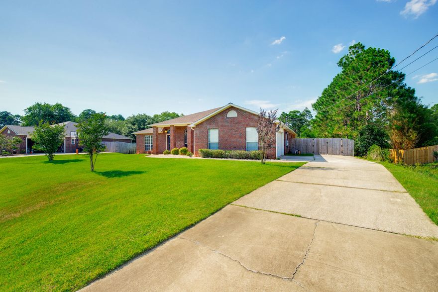 Welcome to this meticulously maintained all brick home in Navarre's Holley By The Sea neighborhood! This spacious property boasts 4 bedrooms, 3 full bathrooms, an office space or bonus room, and a formal dining space. Situated on a 0.453 acre lot with a generous sized fenced in backyard and an extended concrete pad from the side entrance garage and driveway - PERFECT for additional parking or storing your boat or RV behind the gate. Inside this split floor plan home, you'll find gorgeous wood-look waterproof flooring throughout the kitchen, dining, and main living spaces. The eat-in kitchen is a chef's DREAM- with stainless steel appliances, breakfast bar, plenty of cabinet and counter space, pantry, and kitchen island. Looking over the breakfast bar into the living room, you'll see the fireplace and the slider doors that lead to the covered, tiled patio in the beautifully landscaped backyard. Ready for your outdoor entertaining! The primary bedroom has its own wing of the house - just off the living room. Featuring a spa-like ensuite with double vanity, soaking tub, separate walk-in shower, water closet, and a fantastic walk-in closet! On the other side of the house, you'll find the additional bathroom, 3 additional bedrooms - 2 of which share a Jack & Jill bathroom - and the laundry room. Roof replaced in 2014. Brand new HVAC system in 2022, and new water heater in 2021. Outside fence and gates were replaced in 2023. The property also has a garden box, Lawn Pump/Sprinklers, a shed out back for extra storage, and no neighbors behind you. Another perk - enjoy access to all of Holley By The Sea's amenities with your HOA membership - including a boat ramp, 8 clay tennis courts, a community event hall, 3 different pools, exercise room, and more! Schedule your showing today and make this house your HOME!