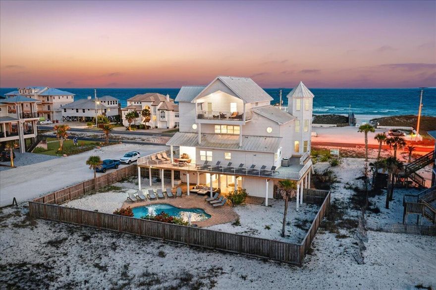 Welcome to 'The Sandcastle,' a rare coastal retreat and one of the largest private pool homes on Navarre Beach. This 3-story beach home sleeps 24 and offers exceptional rental potential with $145,000 in rental history. Thoughtfully updated with designer furnishings, refreshed showers, and renovated bathrooms, the home features 5 bedrooms, attached suites in 4 bedrooms, and 5 bathrooms. Located directly across from the Gulf in a quiet stretch of Navarre Beach, each bedroom enjoys balcony views, with no future building expected to obstruct the Gulf views. A fenced private pool, covered lounge area, and spacious patio create the perfect setting for relaxed beach living.  Relax by the pool in the evening with sound views in the back of the home.
