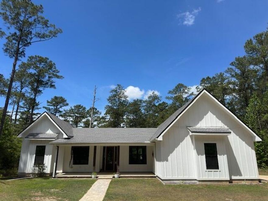PEACEFUL, SECLUDED RETREAT. A must see! Rare opportunity to own 3.04 unrestricted acres outside the Freeport city limits. This custom farmhouse is ready for you to make it your home. Imagine waking up to a backyard full of songbirds on your own private estate. This custom-built farmhouse is a true homesteader's dream. A warm, welcoming space ready for you to fill with laughter, memories, and the simple joys of country living. The wooded driveway provides privacy on all sides and leads you to the farmhouse of your dreams. Step inside through the inviting entryway that flows seamlessly into an open-concept living room and kitchen, where natural light fills the space and every moment feels connected. Perfect for family gatherings, holiday cooking, or quiet evenings together. Custom built-in pantry cabinets keep everything beautifully organized, brand-new stainless steel appliances and the 36" gas range make cooking a joy, and the thoughtful layout invites everyone to linger long after dinner is done. Every room in this home boasts soaring 10 ft ceilings. For the creative or productive soul, the fully insulated studio/office space (currently set up as a recording studio) offers endless possibilities: a home office, art studio or workspace. Fresh interior and exterior paint gives everything a crisp, clean canvas for your personal touches. The spacious master suite boasts 12 ft ceilings and a private entrance to the back porch, where morning light pours in. Unwind in the luxurious master bath with its deep soaking tub and spa-like shower. His and hers walk-in closets offer plenty of room for everything you love. The thoughtfully designed layout features 3 generous guest bedrooms and 2 full baths, one of which has an exterior door. With this layout, a pool would be the perfect addition to the backyard. Outside, the large screened porch is pure magic; ideal for quiet early-morning coffee with the sunrise or watching summer sunsets paint the sky. Towards the middle of the property, a large chicken coop with fencing is ready for your farming dreams. The firepit is perfect for ending your evening surround by family. The back of the property is still wooded; a blank canvas for gardening, farm animals or whatever your heart envisions. Abundant wildlife and wild blueberry and blackberry bushes are also sprinkled throughout the property. You're only 8 minutes to Freeport for everyday conveniences, yet just 25 minutes from the sugar-white sands and emerald waters of 30A beaches. Head 45 minutes to vibrant Panama City or Destin for dining, shopping, and entertainment. All while returning each evening to your own tranquil slice of Florida. This is more than a house; it's the cozy, peaceful homestead you've been envisioning. A rare opportunity to own unrestricted land with room to garden, roam, or simply breathe. Come make it your home.
